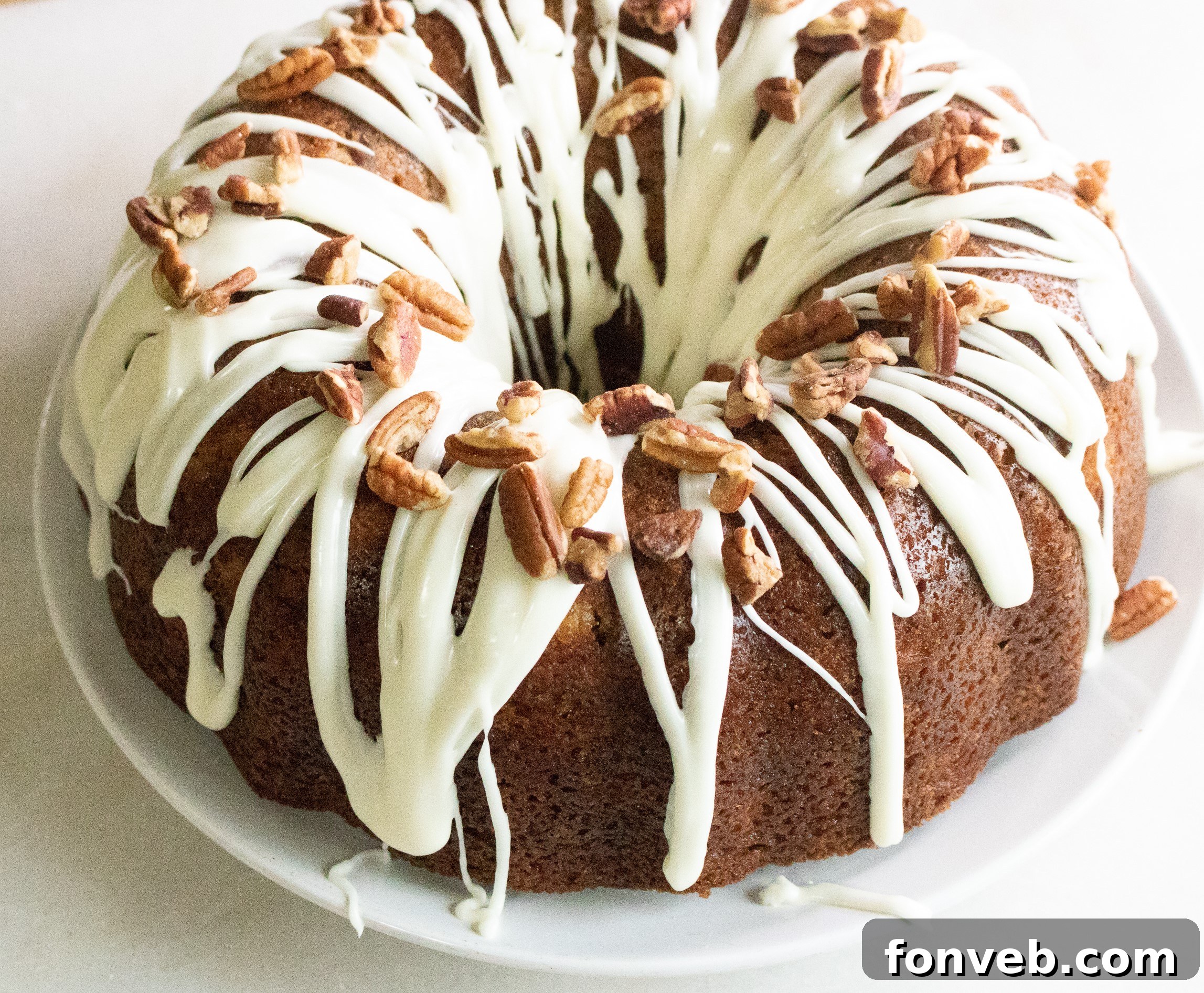 A close-up of a slice of Southern Hummingbird Bundt Cake, showcasing the golden-brown exterior and the moist, fruit-speckled interior