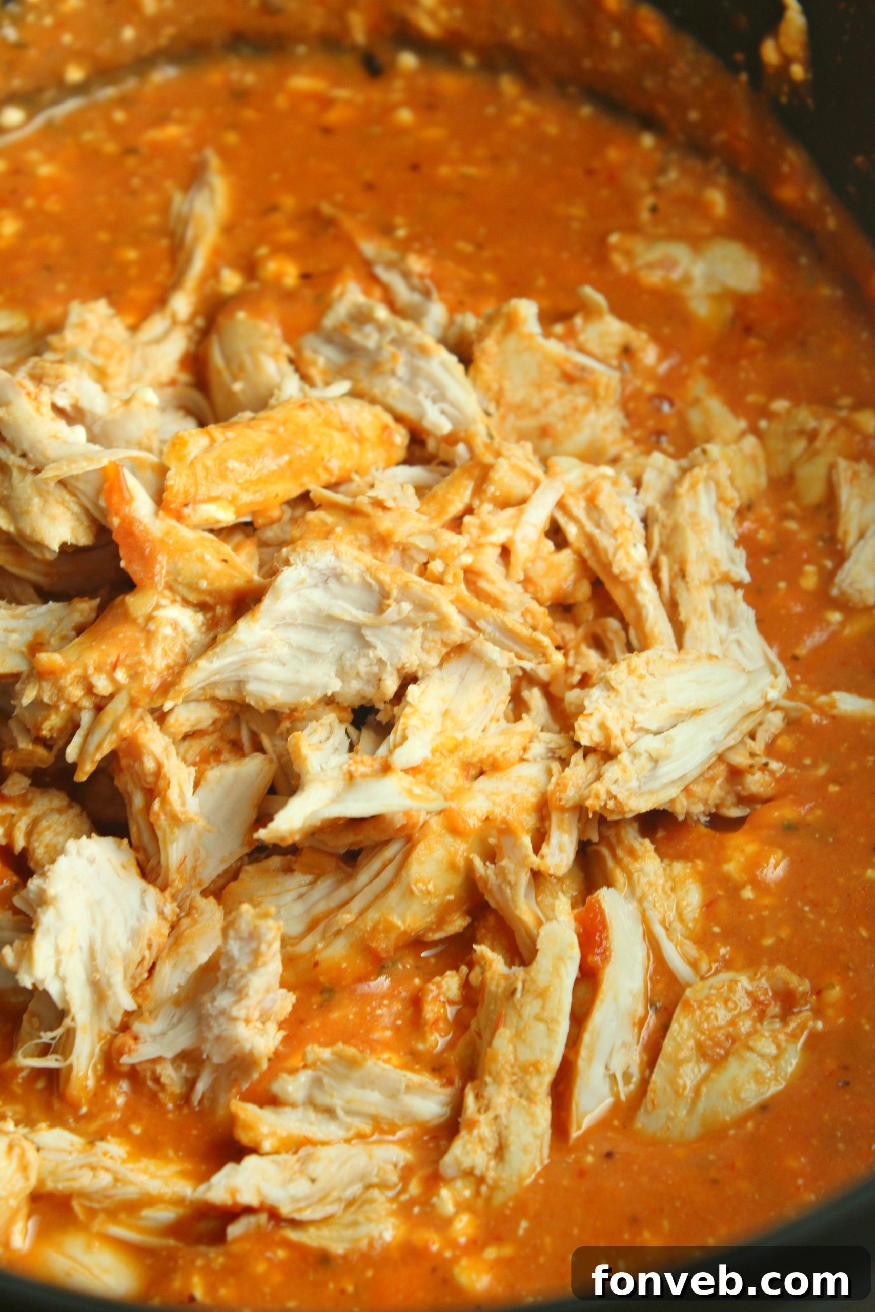 Velvety Slow Cooker Chicken Rigatoni 4 Slow cooker creamy chicken rigatoni served in a rustic bowl, with a spoon revealing its creamy texture.