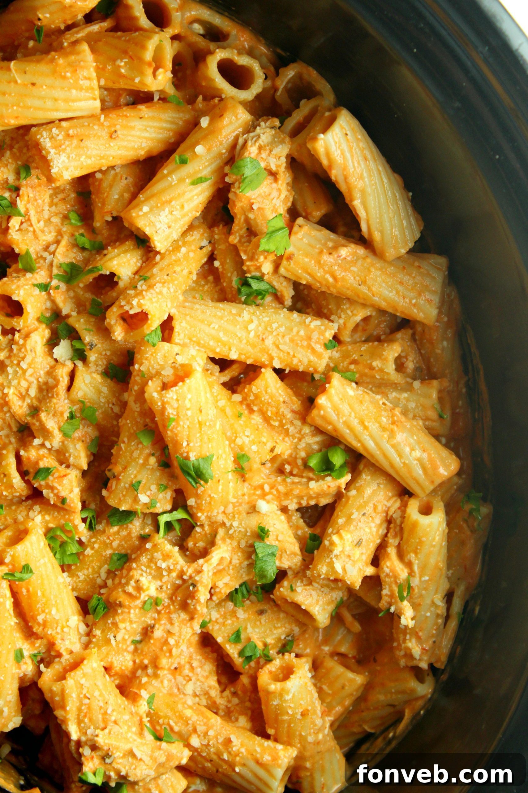 Velvety Slow Cooker Chicken Rigatoni 7 Slow cooker rigatoni with chicken, elegantly plated with a sprig of fresh basil.