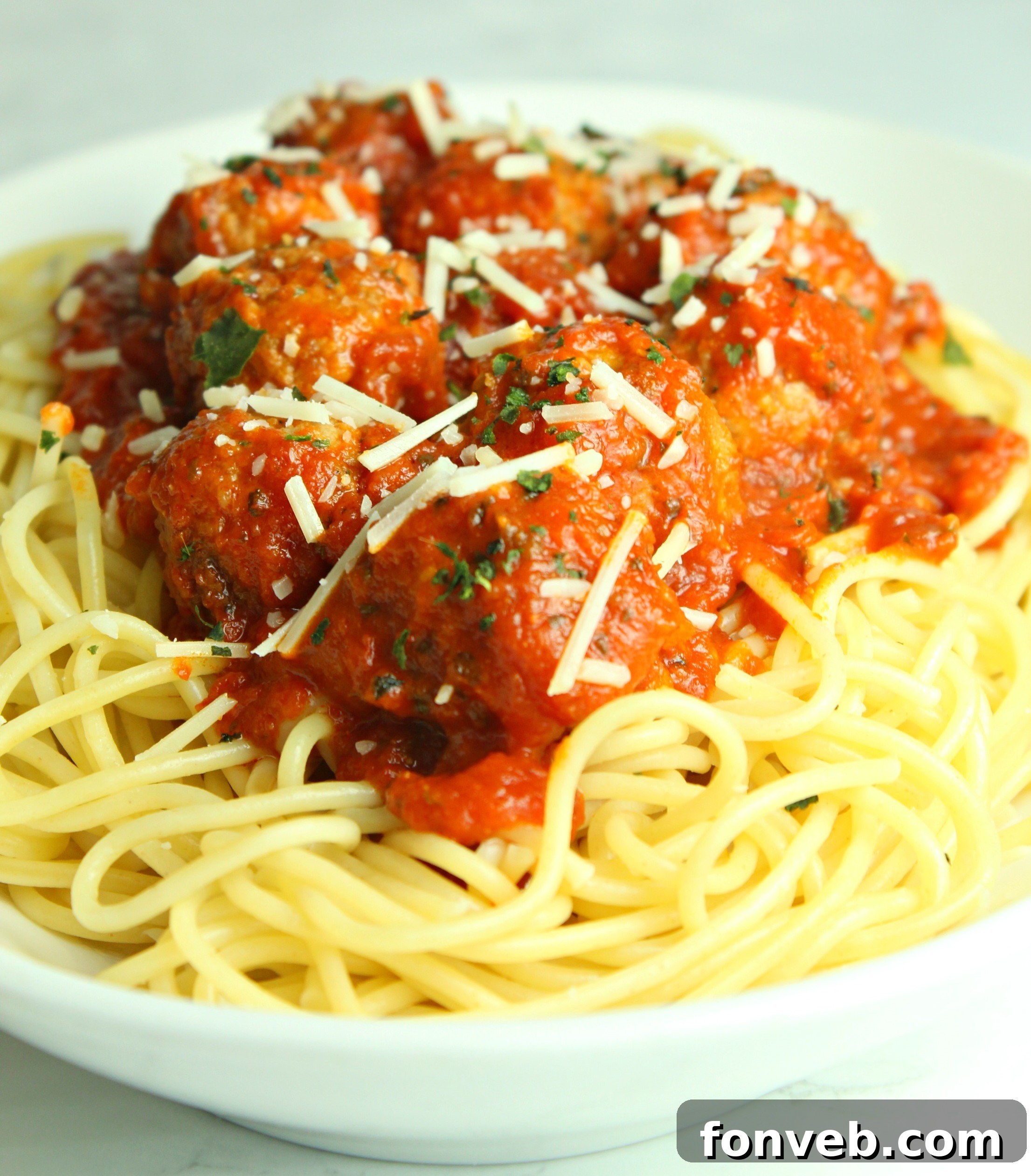 Slow cooker meatballs and sauce on a spoon