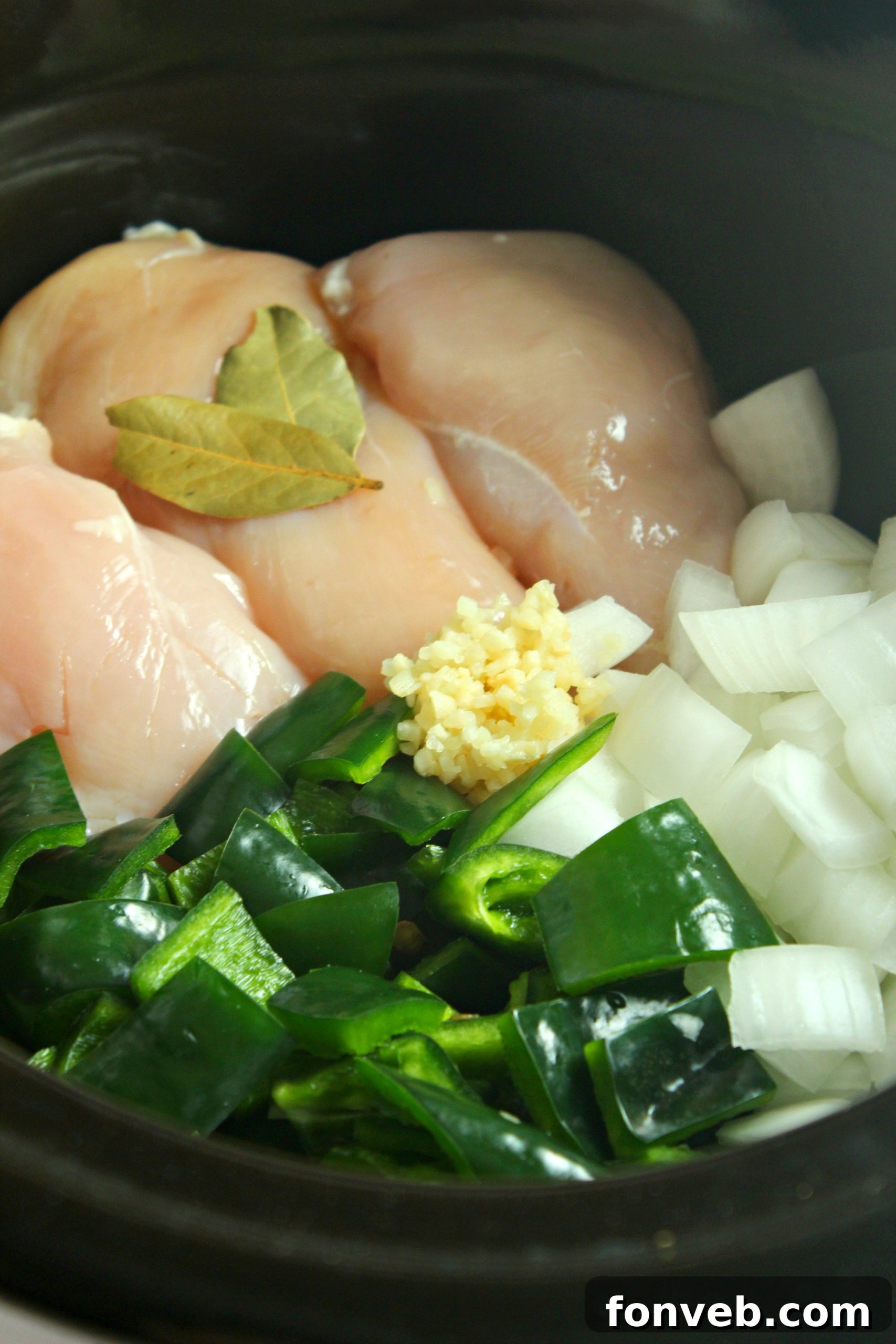 A vibrant bowl of Slow Cooker Chicken Chile Rellenos Soup garnished with fresh herbs