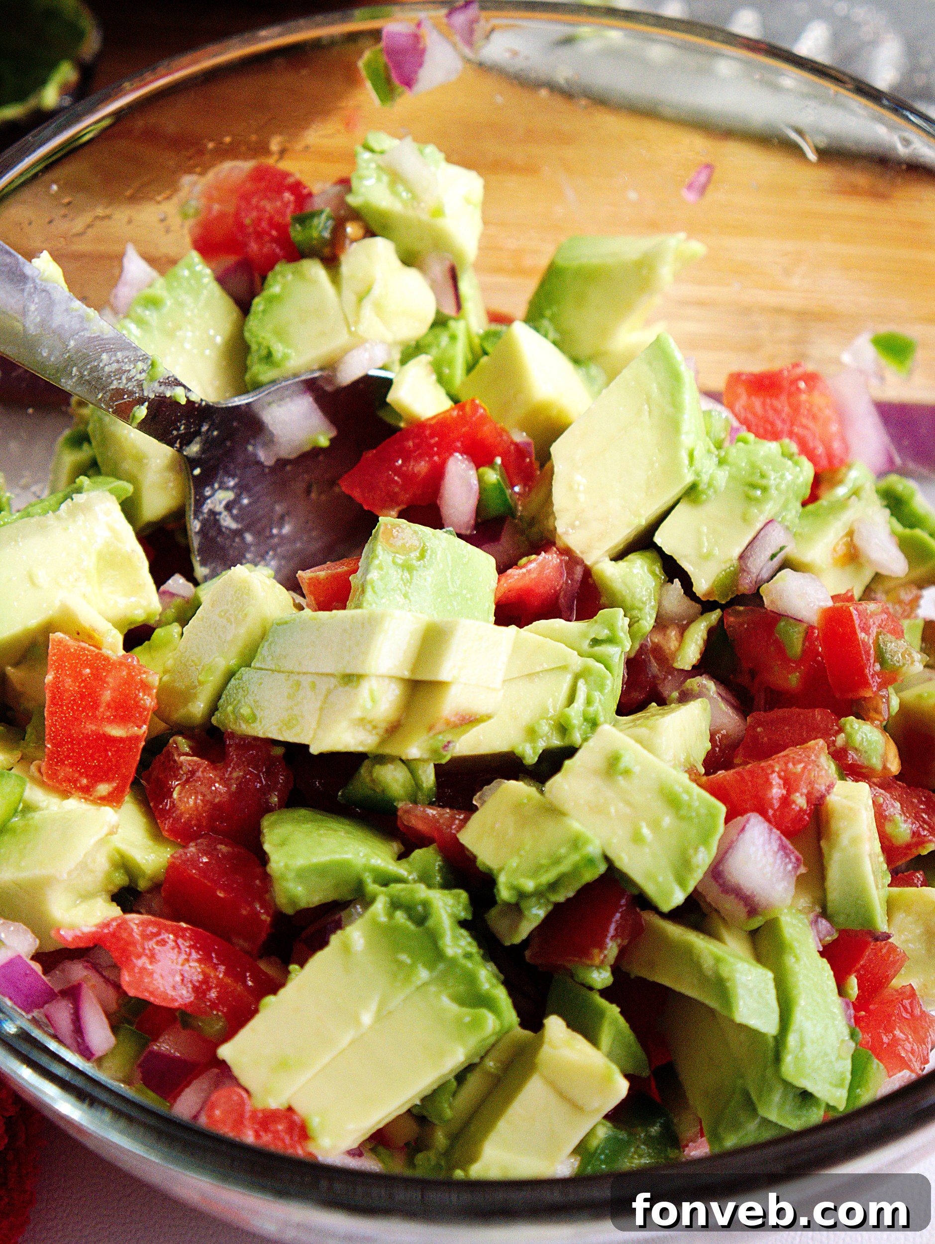 A vibrant green bowl of chunky guacamole, showcasing its appealing texture.