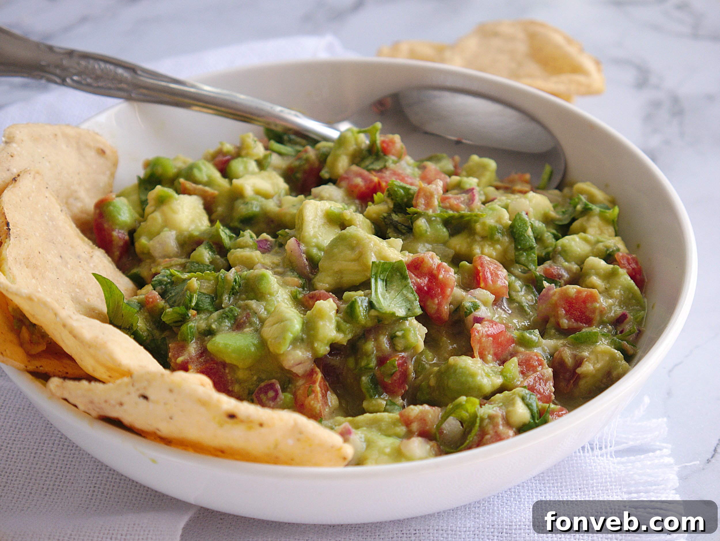 A generous serving of chunky guacamole in a rustic bowl, ready to be devoured.