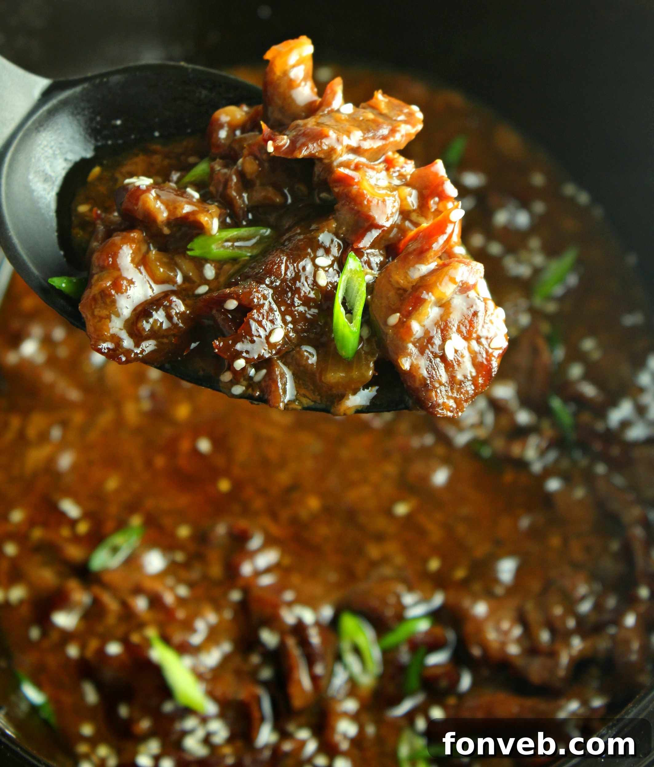 Close-up of Slow Cooker Korean Beef garnished with green onions and sesame seeds