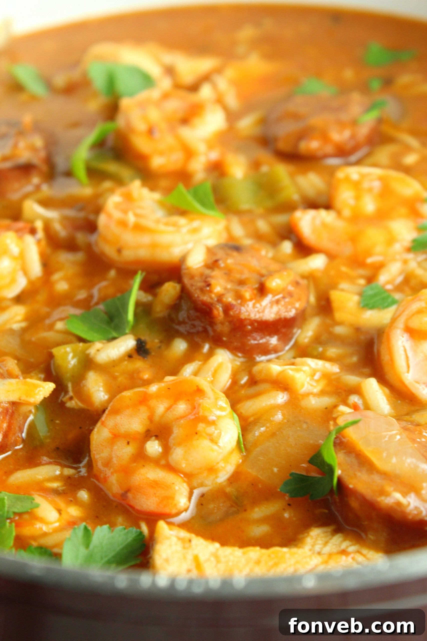 Spicy Cajun Jambalaya Soup 8 A rustic serving spoon dipping into a large pot of Jambalaya Soup, showing the delicious medley of ingredients.