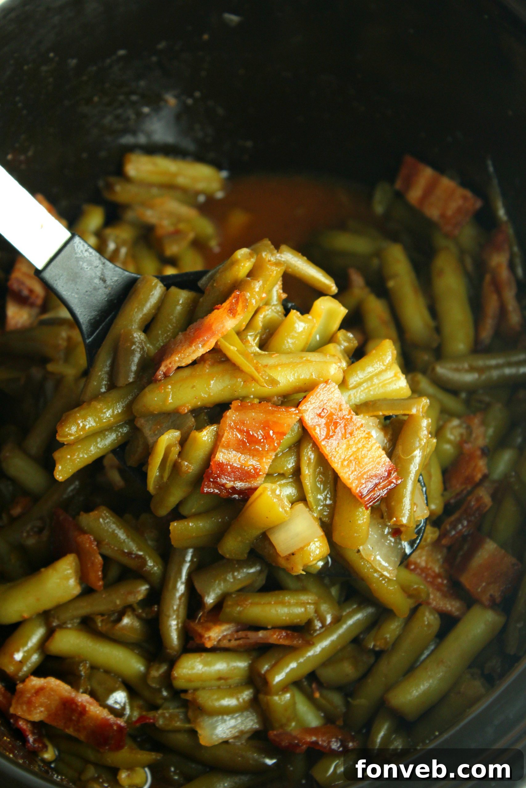 An inviting overhead shot of Slow Cooker Buttery Bacon Green Beans, showing the beautiful texture of the beans and the generous crumbled bacon topping.