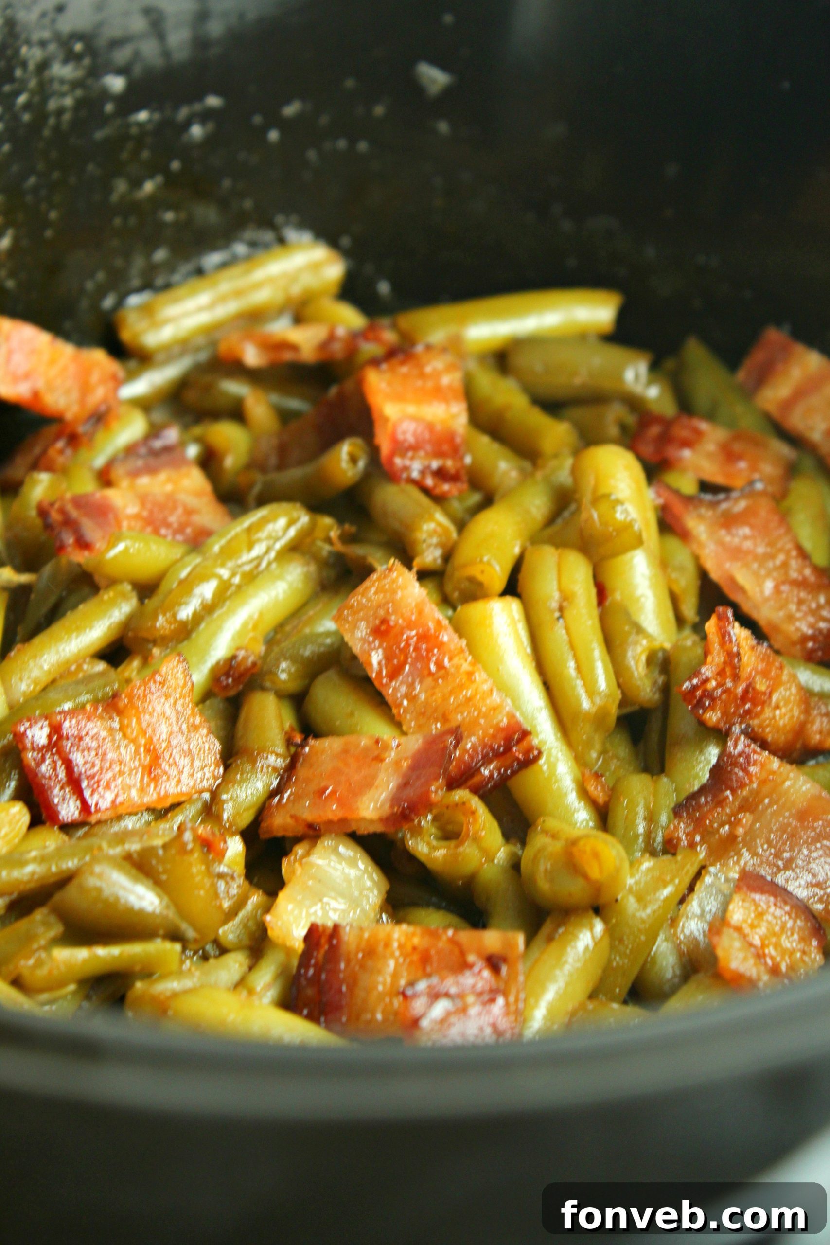 A close-up of the irresistible texture of Slow Cooker Buttery Bacon Green Beans, highlighting the rich sauce and bacon.