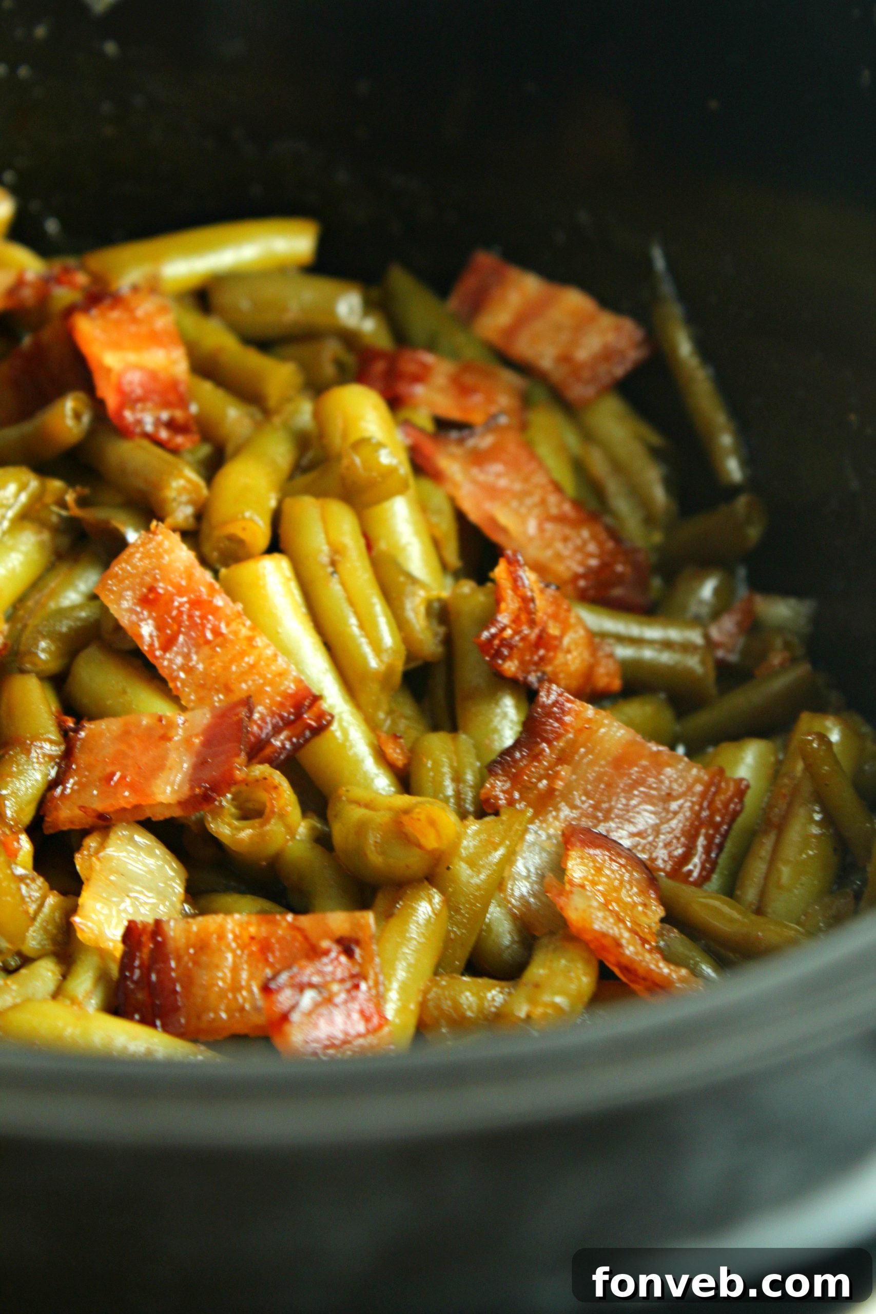 A single serving of Slow Cooker Buttery Bacon Green Beans on a pristine white plate, showcasing its appetizing appearance.