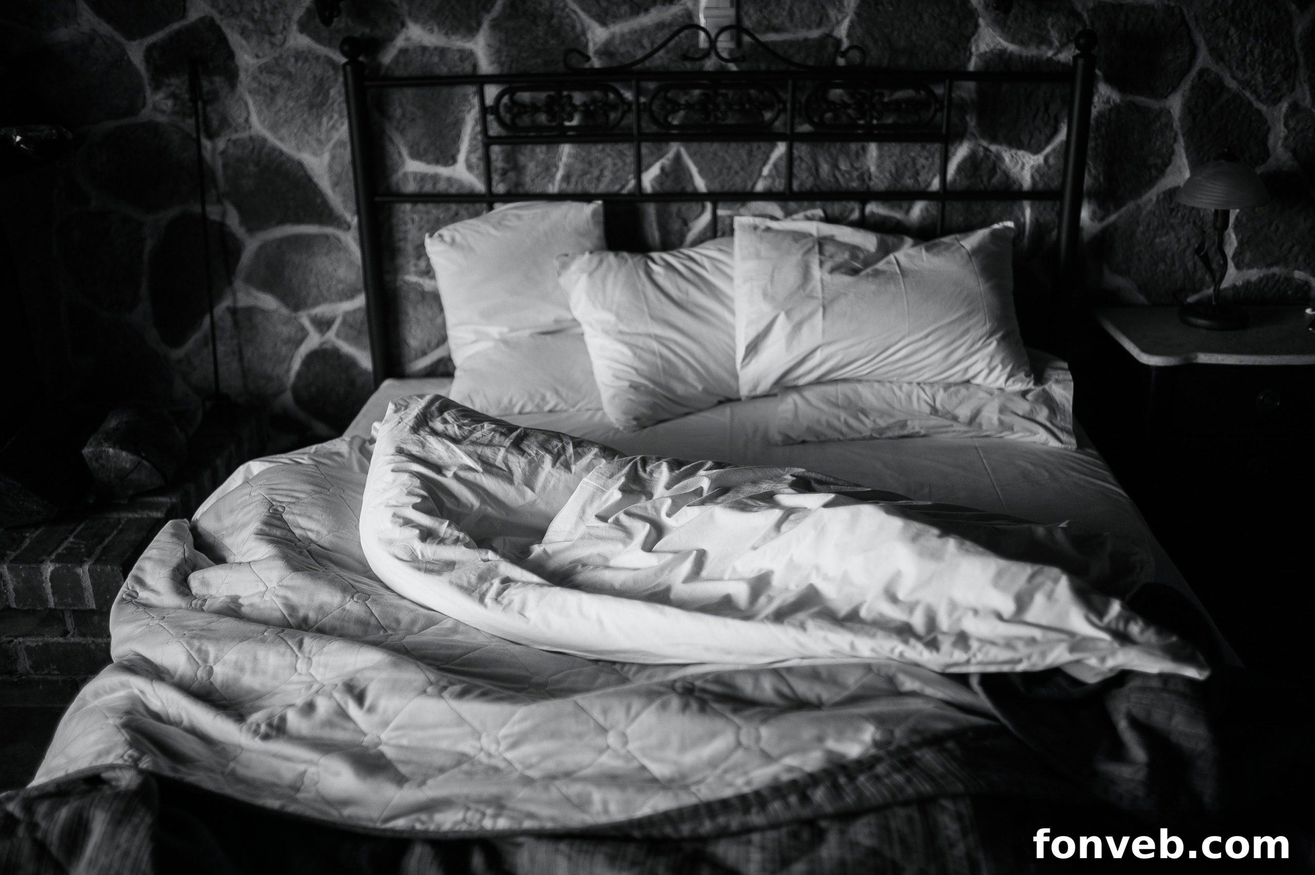 Unmade bed with duvet thrown back, allowing it to air out