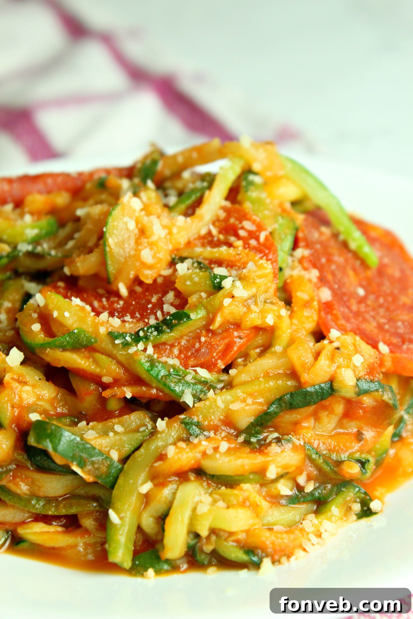 Freshly cooked zucchini pasta shimmering in a pan, ready for sauce