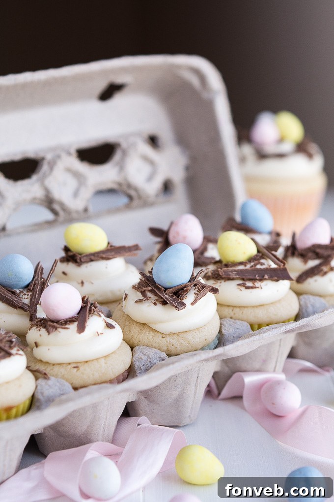 A selection of spring-themed cupcakes, artfully arranged with various Easter decorations like mini eggs and sprinkles.