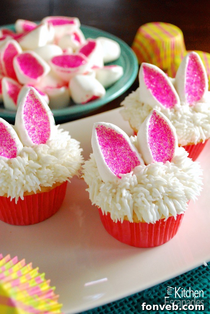 Elegant white chocolate Easter egg cupcakes adorned with colorful pastel frosting and speckled mini chocolate eggs.