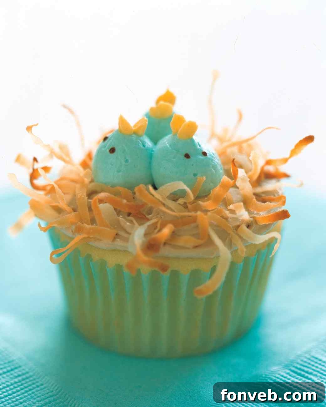 Bright yellow Easter chick cupcakes with candy eyes and orange beaks, resembling cute baby chicks.