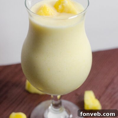 A close-up of a stylishly presented Drunken Disney Dole Pineapple Whip Margarita.