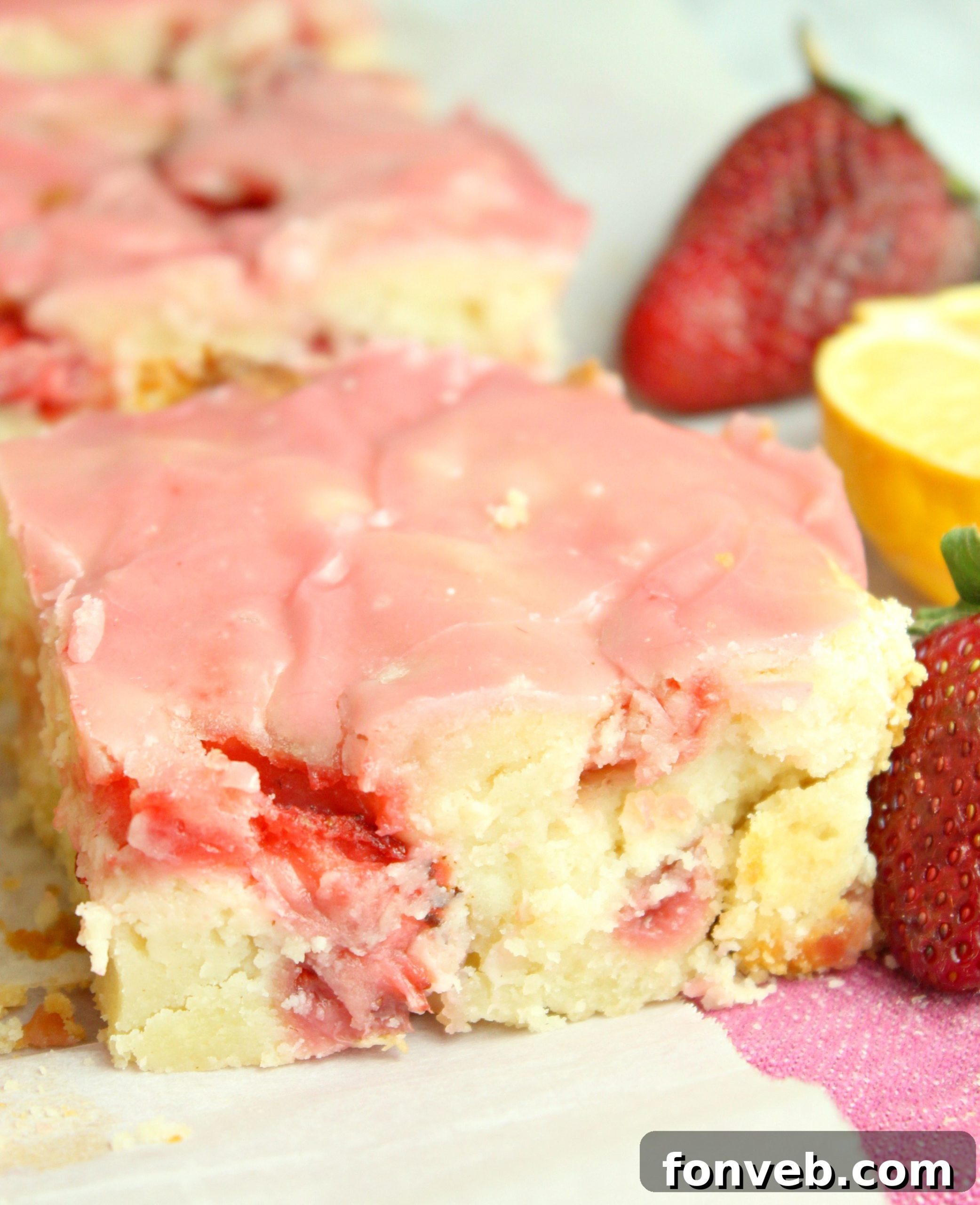 A vibrant display of strawberry lemon blondies with fresh strawberries and lemon slices, ready for a warm weather gathering.