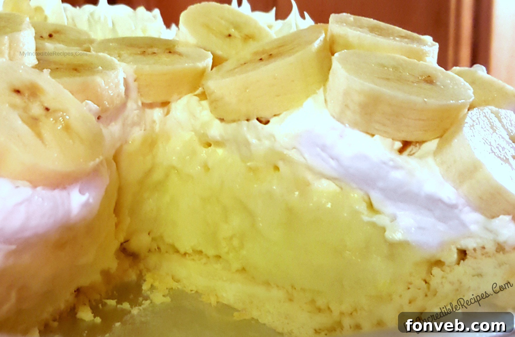 Grandma's Banana Cream Dream 5 A slice of Old Fashioned Banana Cream Pie showcasing its distinct layers of flaky crust, creamy custard, and fresh bananas, topped with whipped cream.