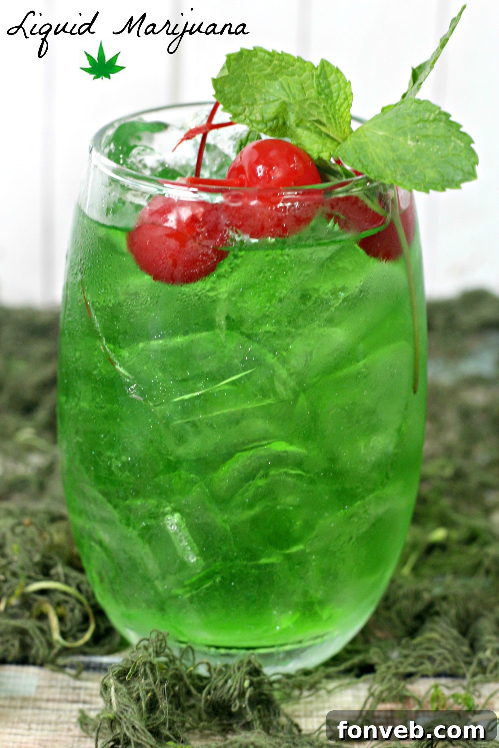 A tall, green Liquid Marijuana Cocktail garnished with lime and apple slices.