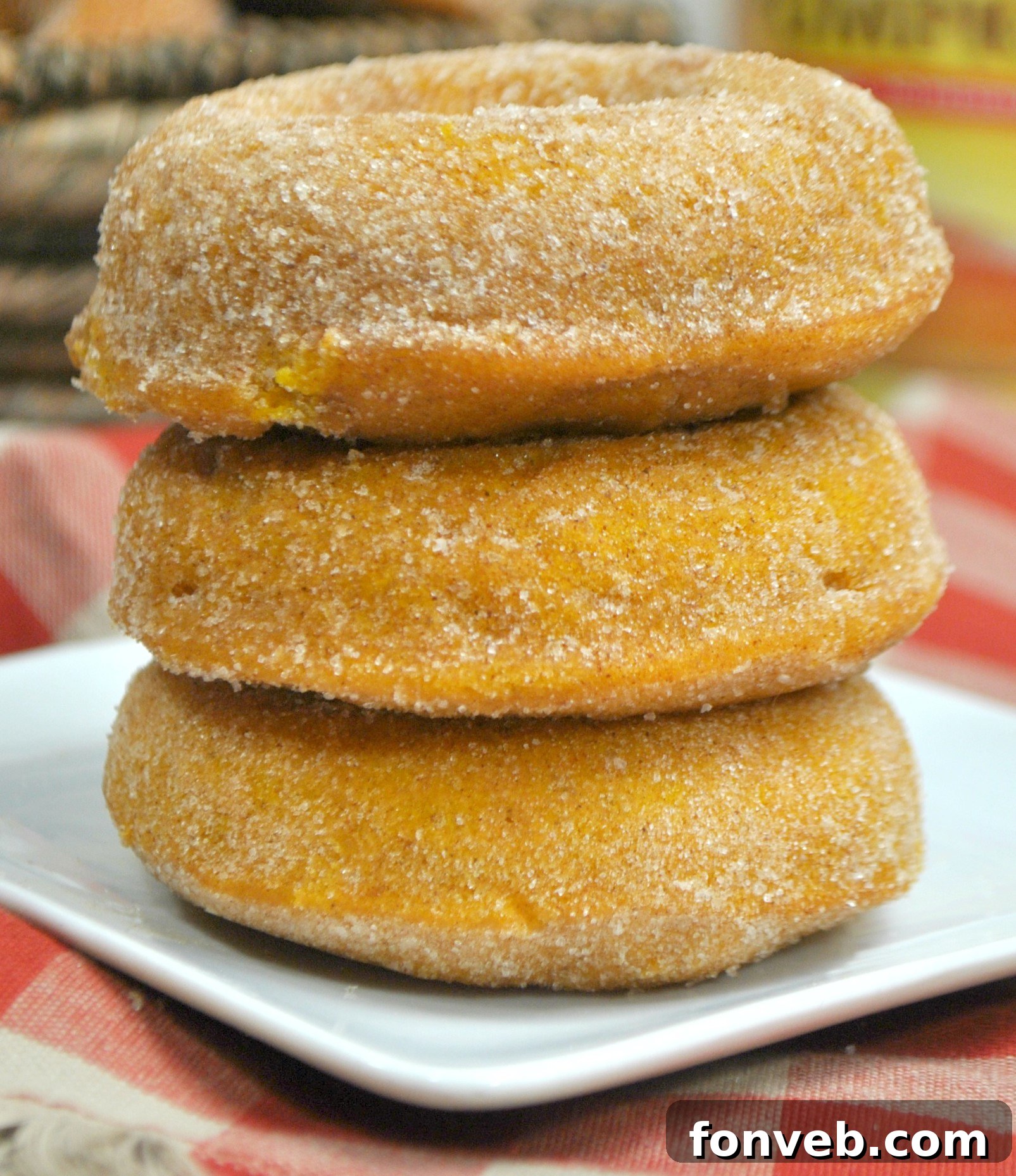 Spiced Autumn Donut Perfection 5 A stack of perfectly coated pumpkin spice donuts, glistening with sugar