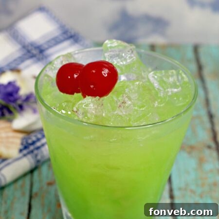 Close-up of a Green Iguana Cocktail in a glass with a lime garnish.
