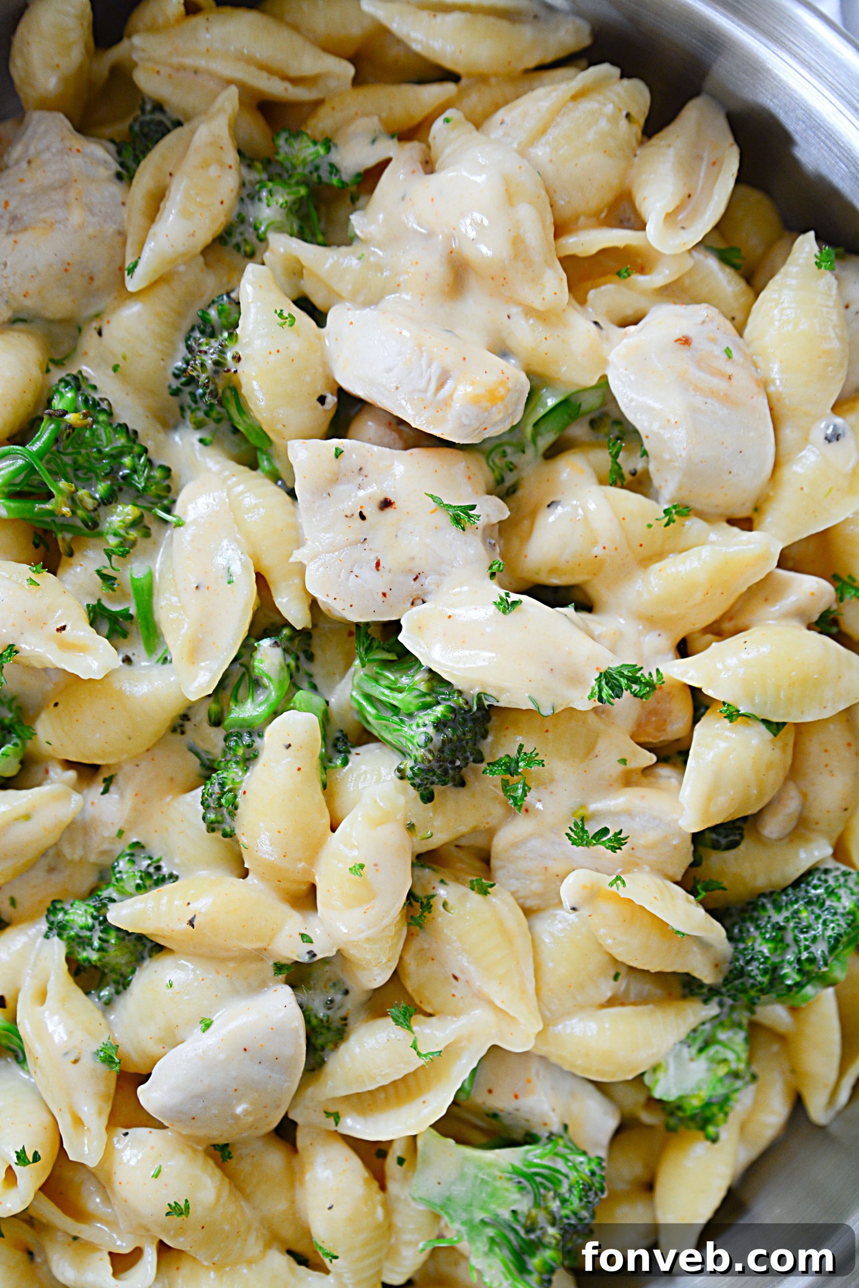 Creamy Cheesy Chicken and Broccoli Shells 4 Close-up of the creamy cheese sauce being stirred in a pot, highlighting its rich texture.