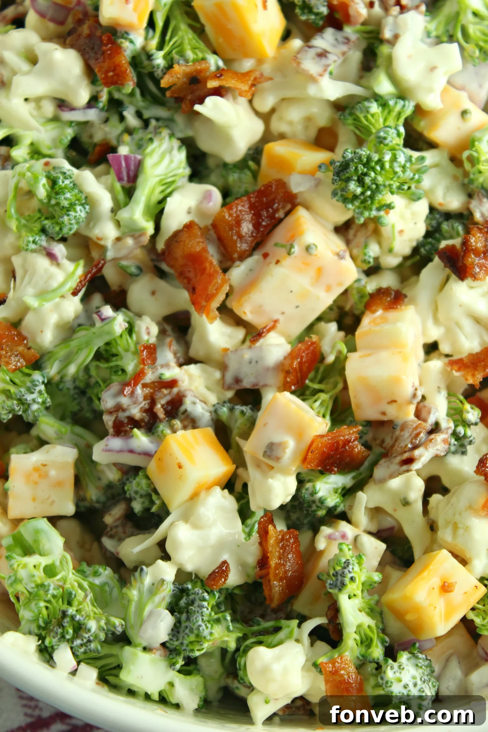 A large bowl filled with the Loaded Broccoli Cauliflower Salad, ready to be served.