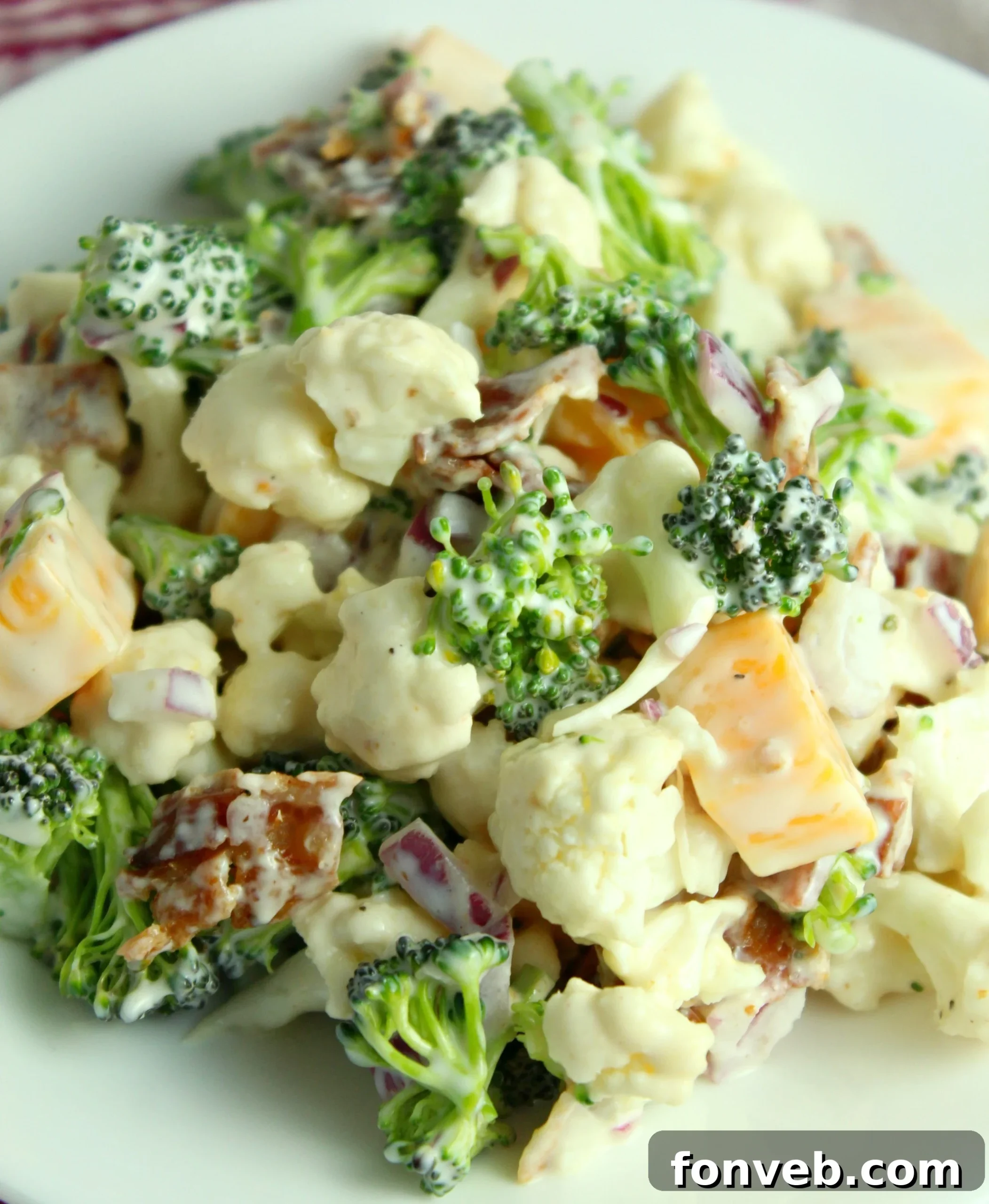 Ingredients for the salad laid out before mixing, including chopped broccoli, cauliflower, bacon, and cheese.