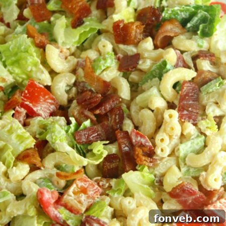 Delicious BLT Pasta Salad in a bowl with a fork, ready to eat.