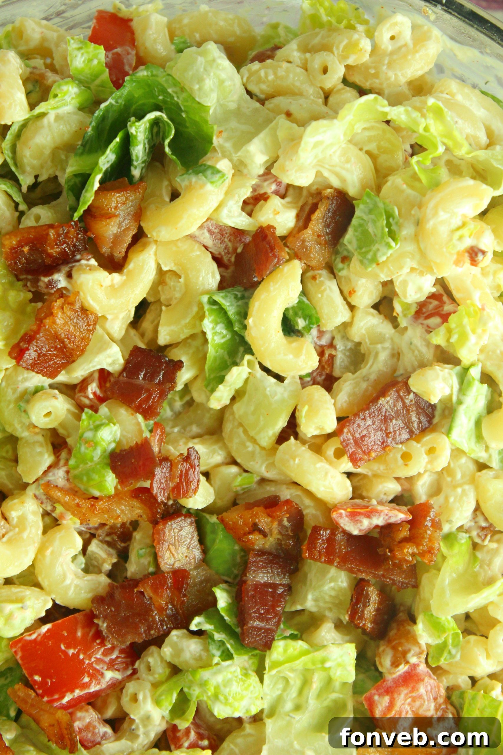 A large serving bowl filled with BLT Pasta Salad, garnished with fresh parsley.