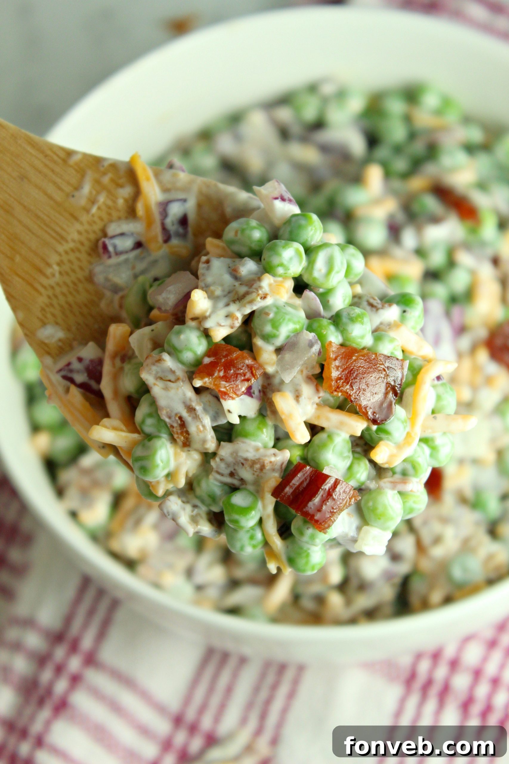 Smoky Bacon and Sweet Pea Salad 3 Close-up of the ingredients for Creamy Bacon Pea Salad, highlighting fresh peas and diced red onion.