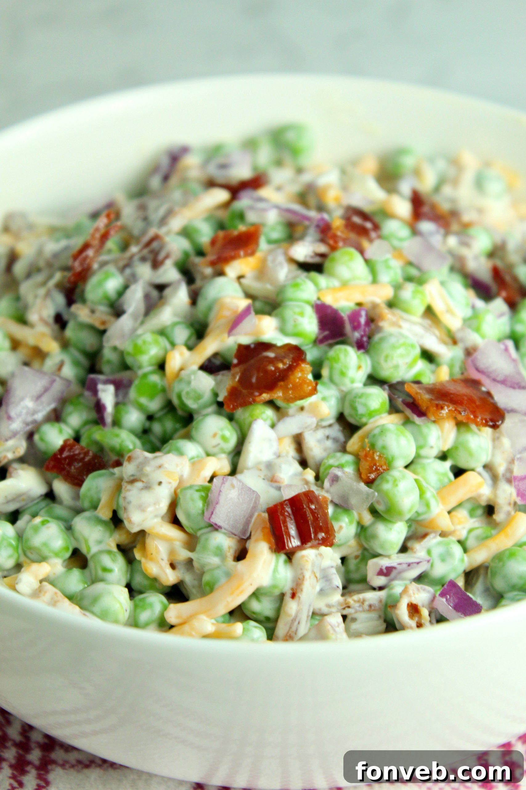 Smoky Bacon and Sweet Pea Salad 6 A large serving bowl filled with Creamy Bacon Pea Salad, ready for a gathering.