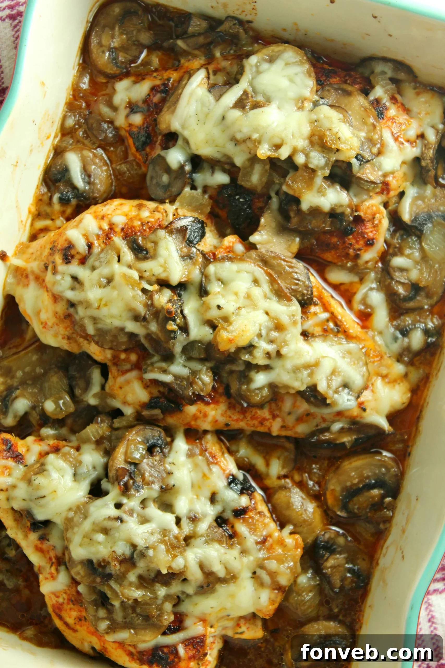 Creamy Cheesy Mushroom Chicken Keto Bake 2 Close-up of Smothered Cheesy Baked Chicken with Mushrooms in a baking dish, garnished with fresh parsley.