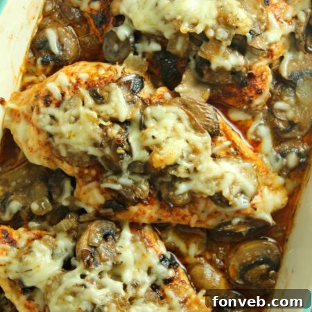 Smothered Cheesy Baked Chicken with Mushrooms in a baking dish