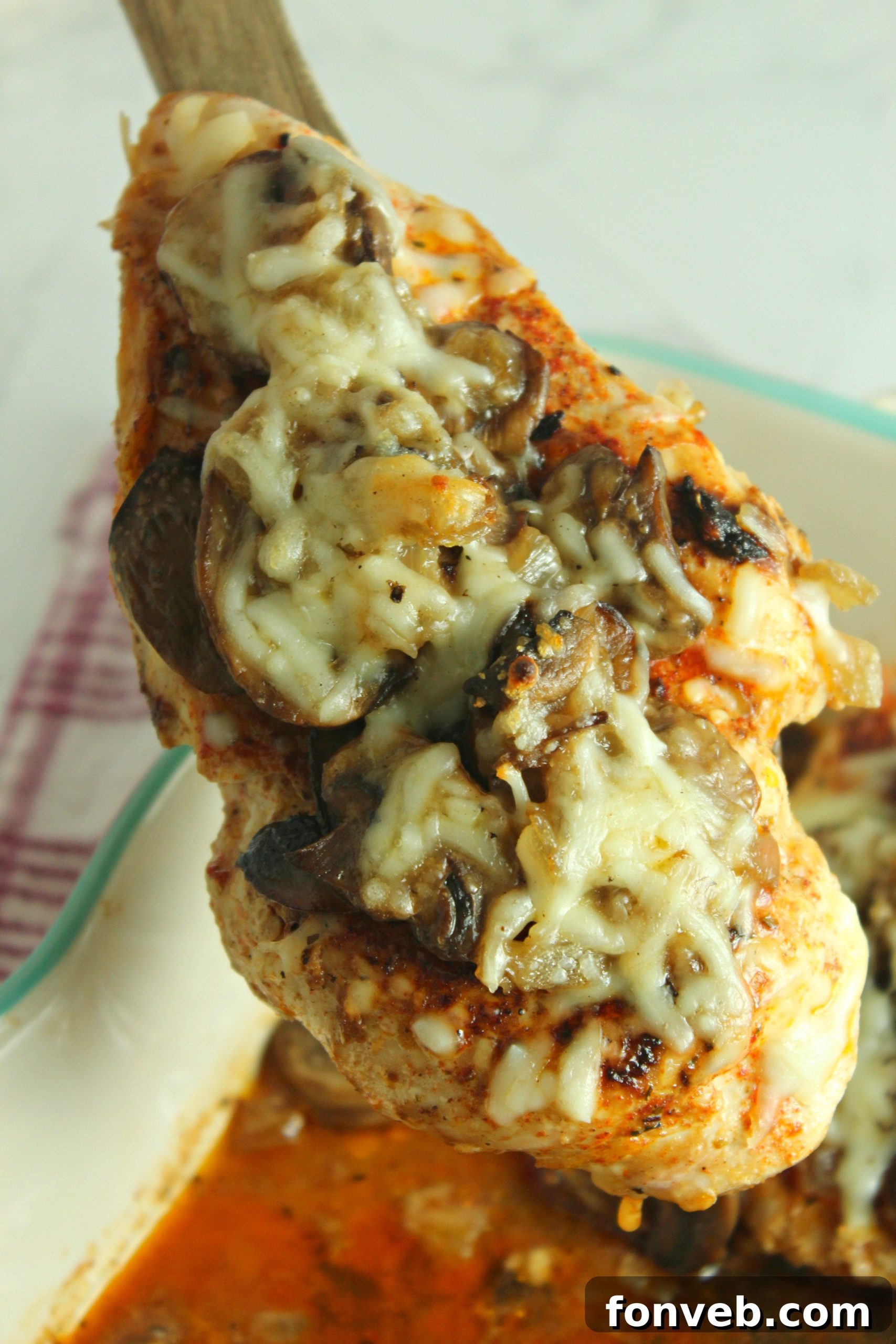 Creamy Cheesy Mushroom Chicken Keto Bake 4 A close-up of a skillet filled with sliced mushrooms and onions, caramelizing before being added to the chicken dish.
