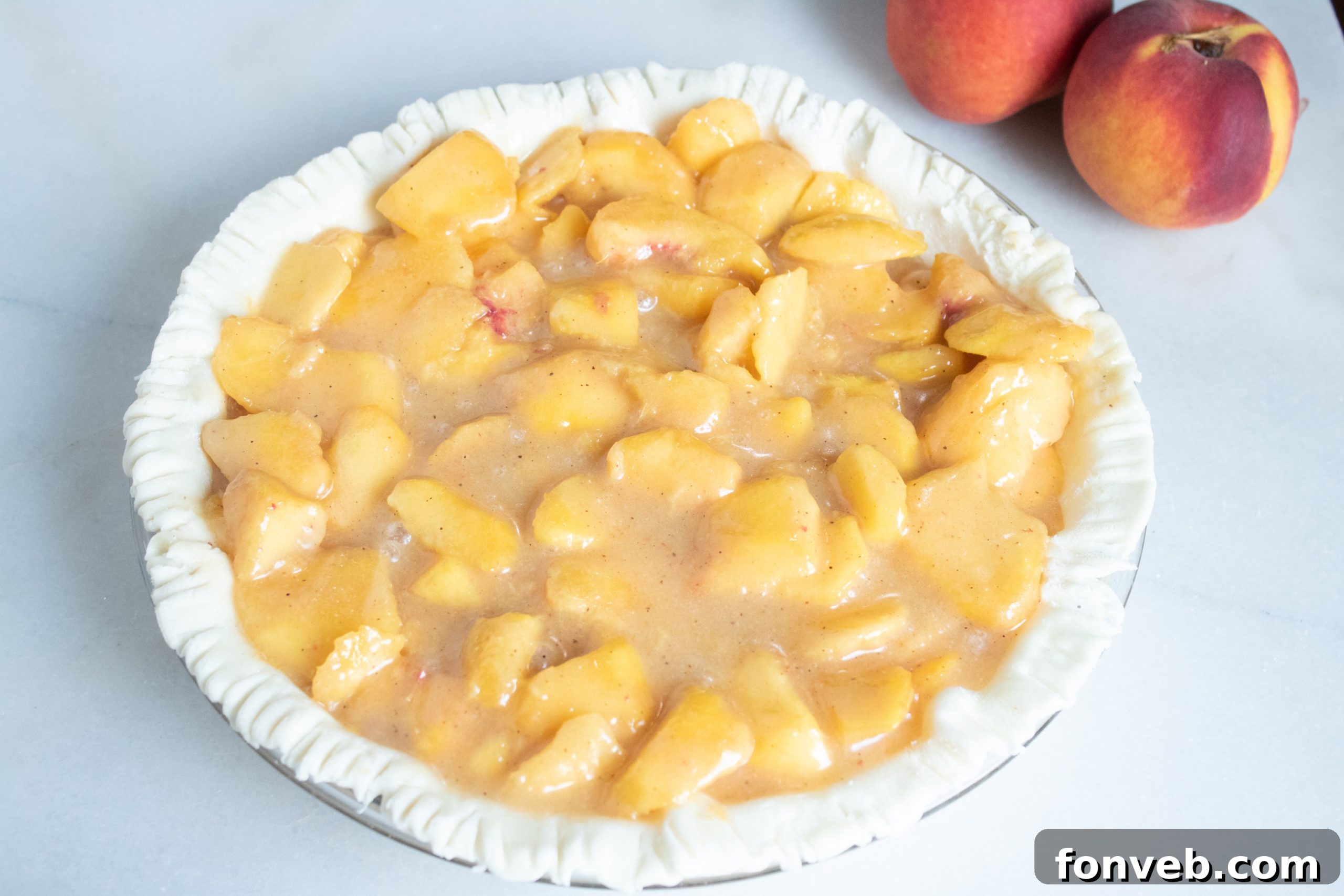 Close-up of a generous slice of Southern Peach Pie, revealing the vibrant, juicy peach filling and a golden, flaky crust.