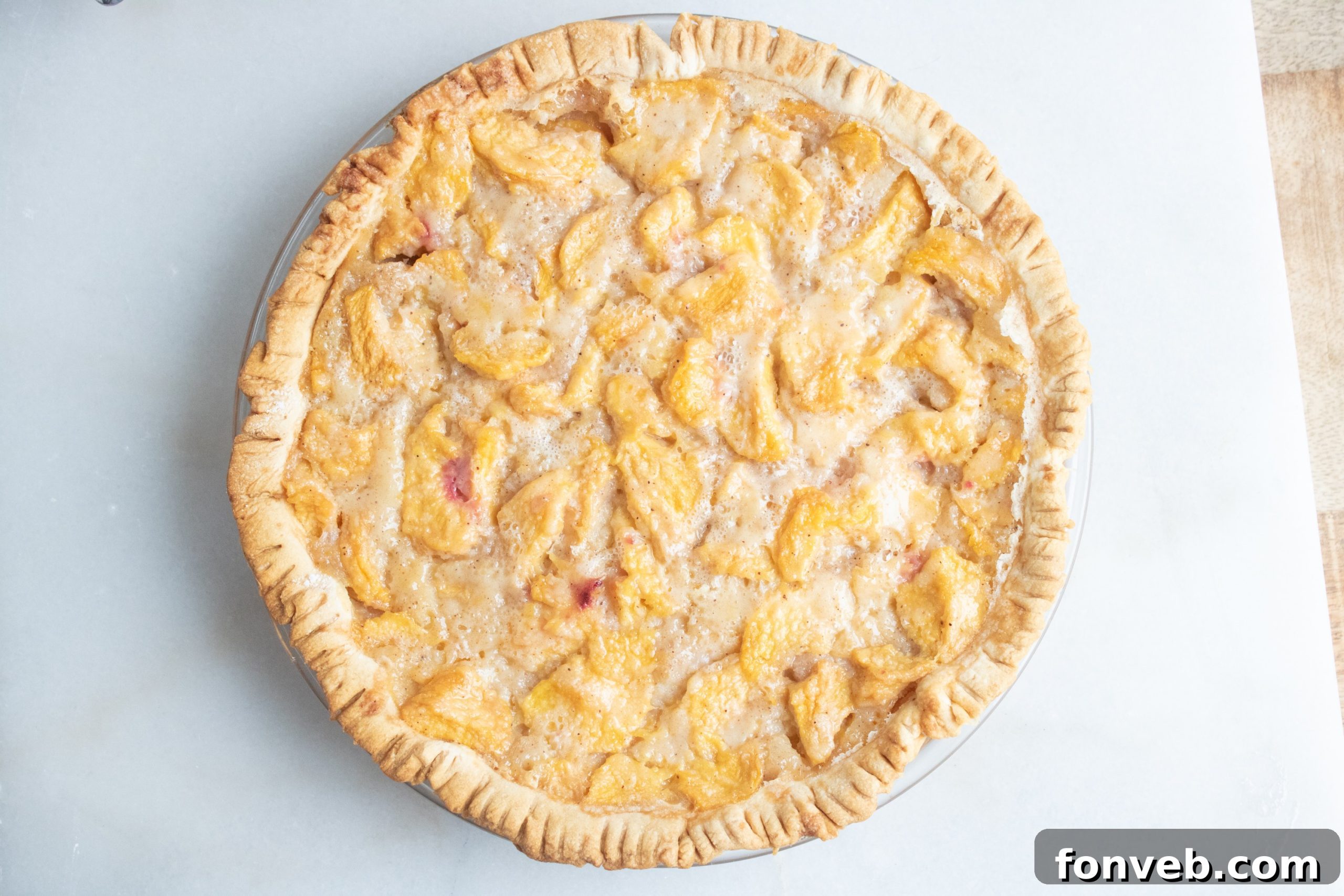 Fresh, perfectly ripe peaches piled high in a basket, ready to be prepared for baking a delicious peach pie.