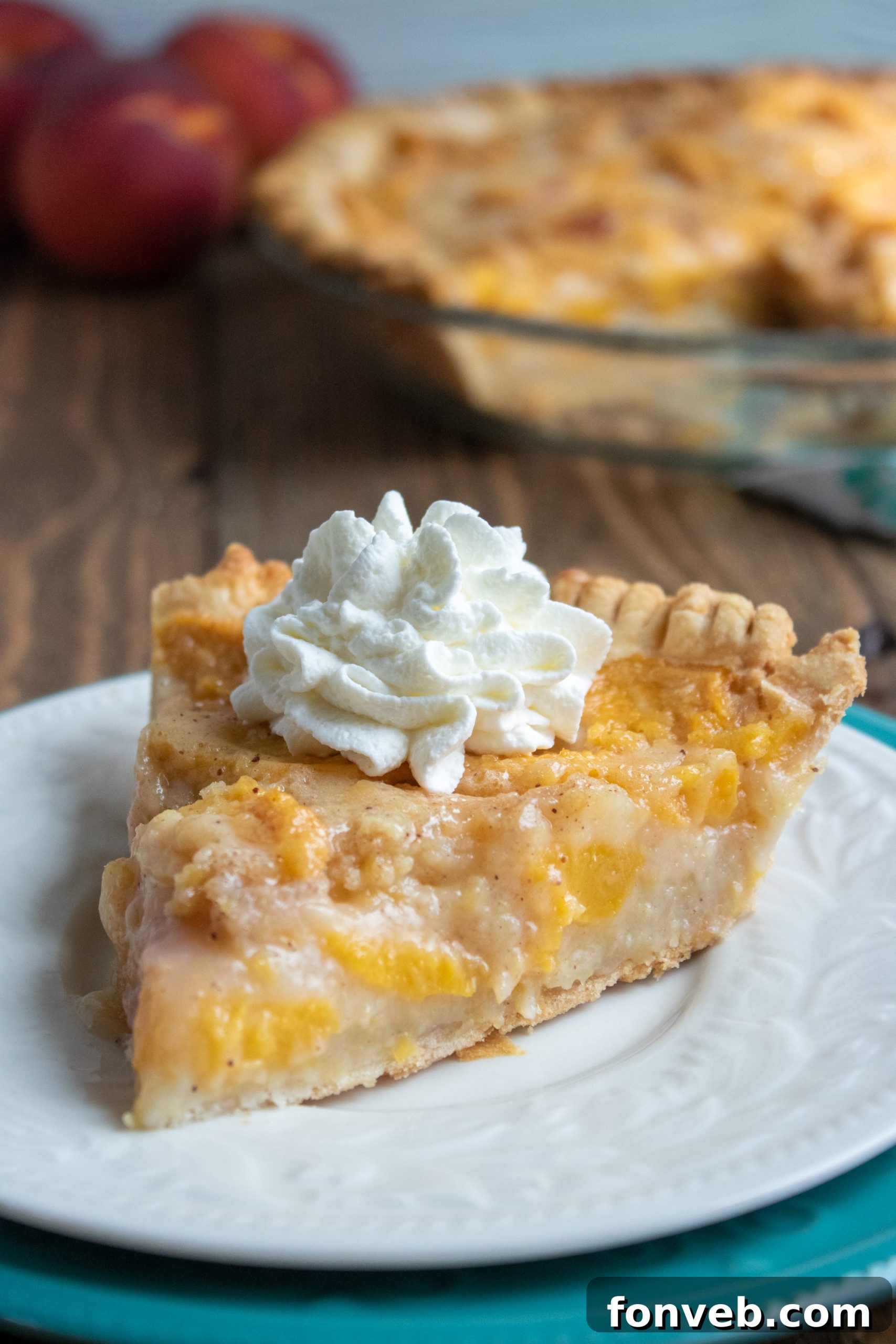 A close-up shot of juicy, perfectly sliced peaches being mixed with the pie filling ingredients in a large bowl.