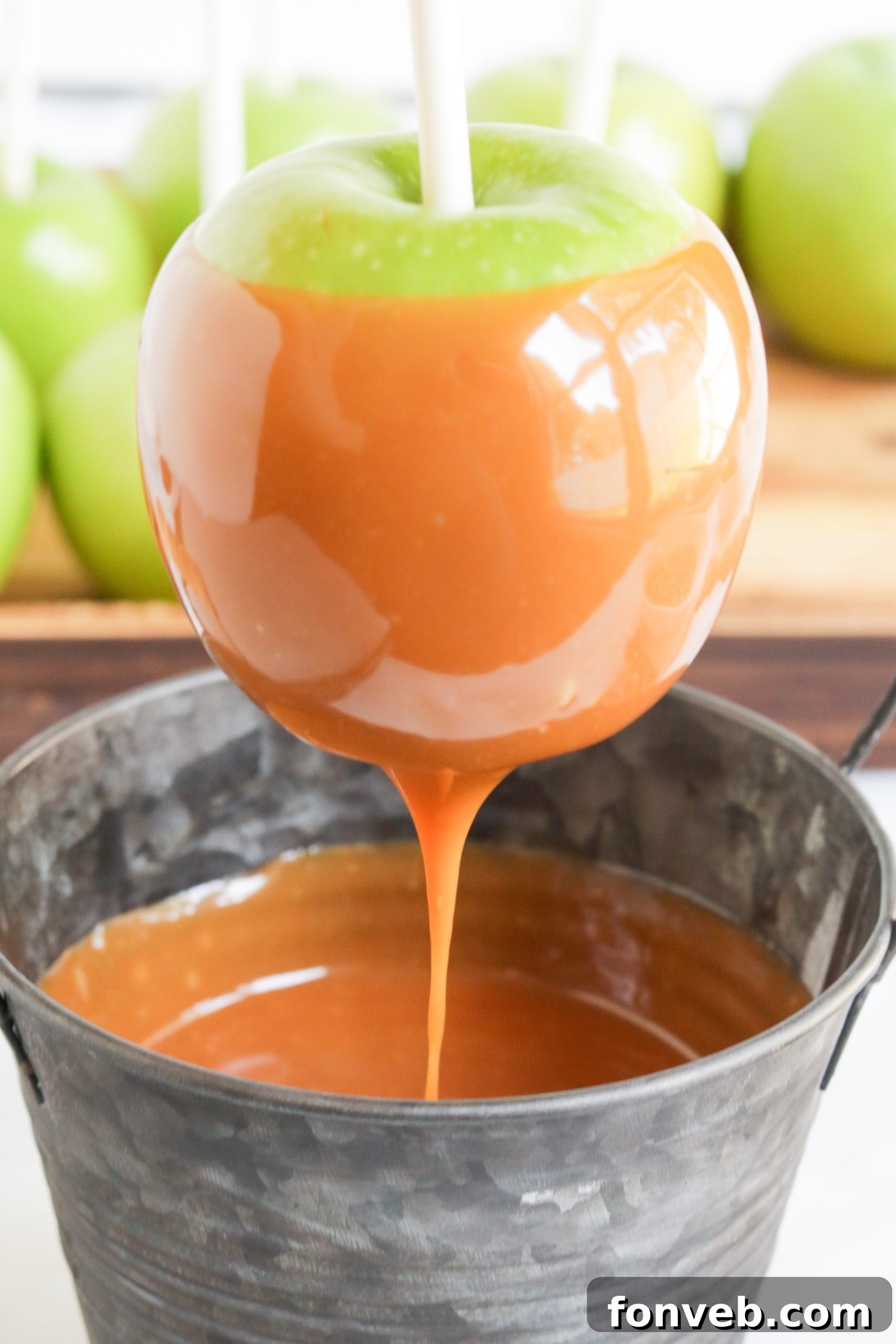Caramel apples on sticks ready for dipping.