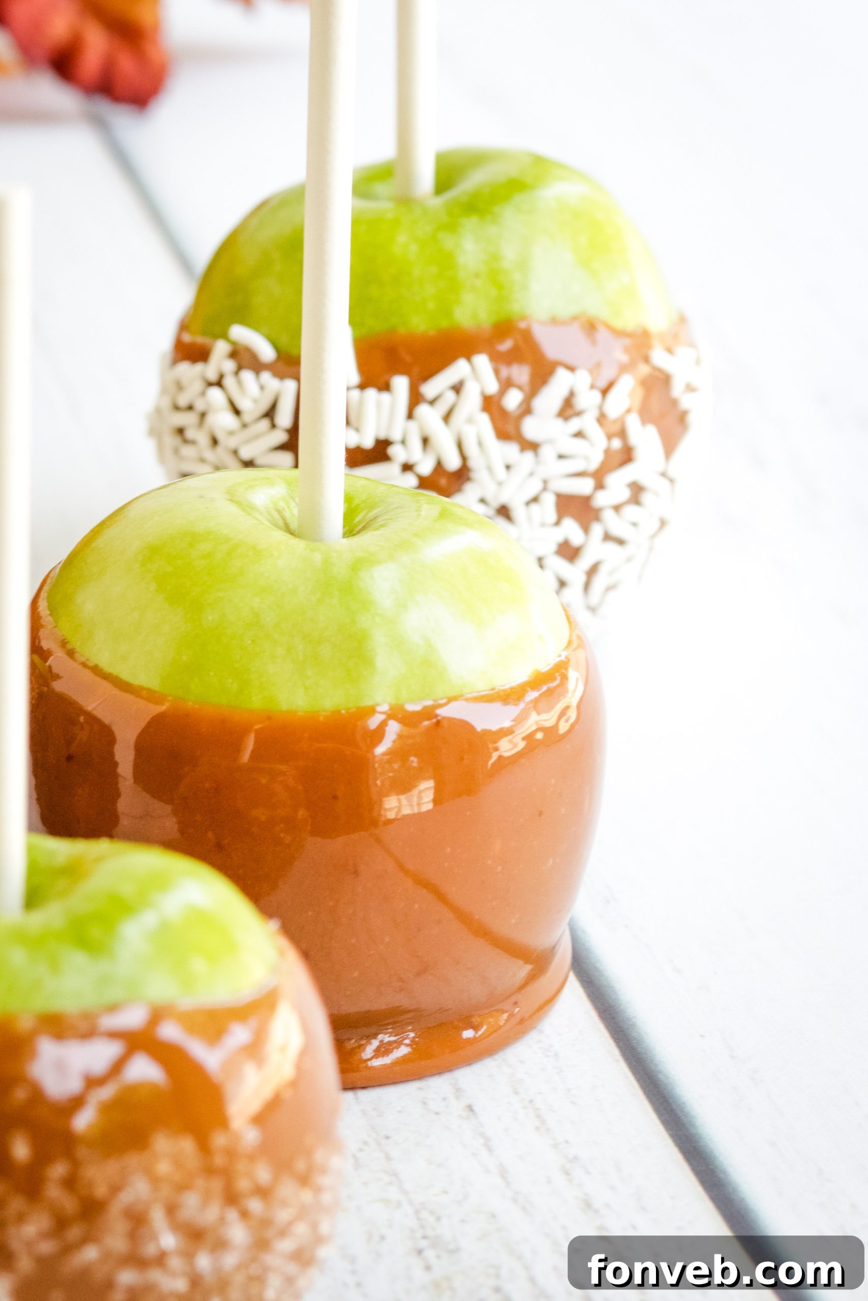 Variety of caramel apples with different toppings.