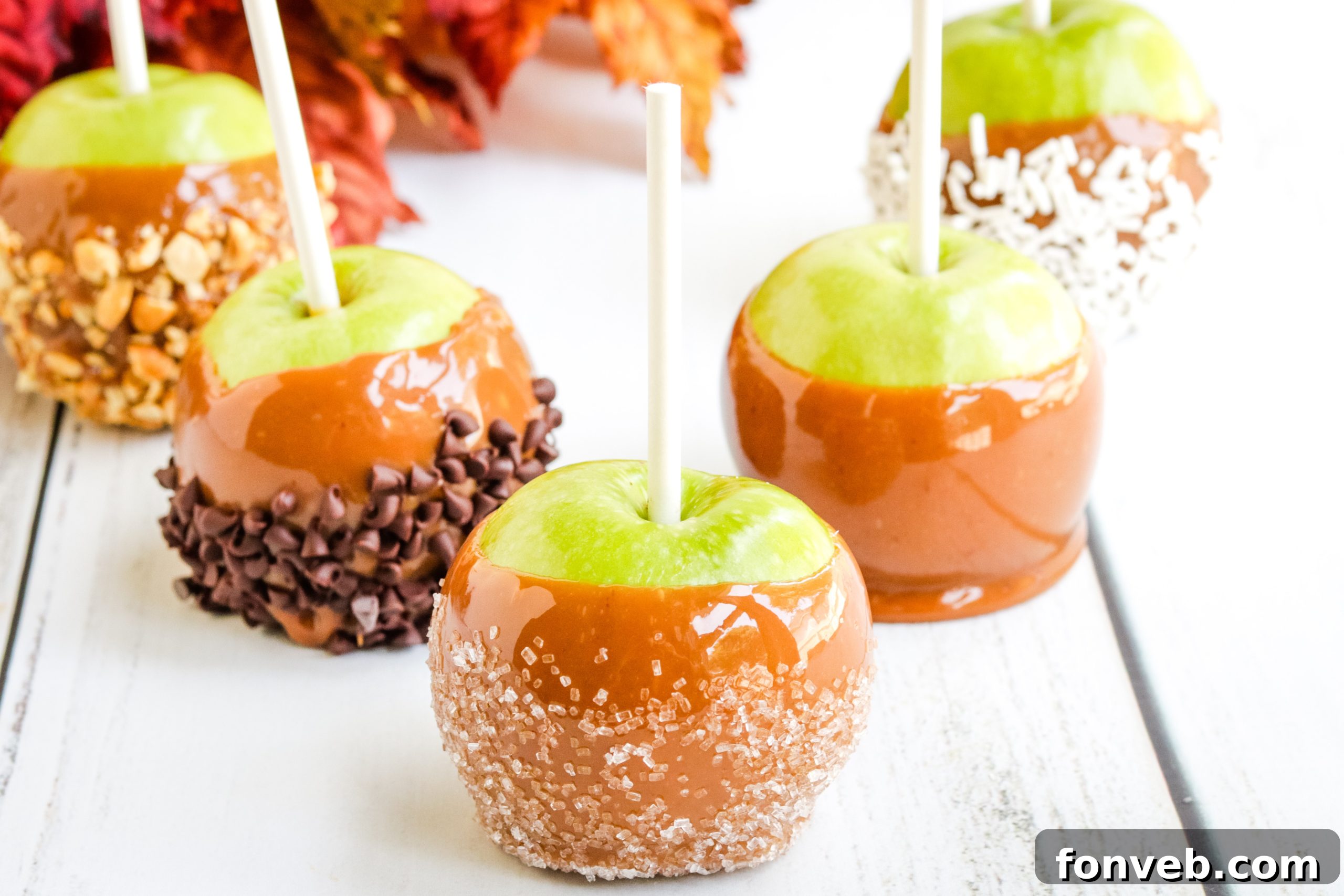 Caramel apples, some plain, some with sprinkles.