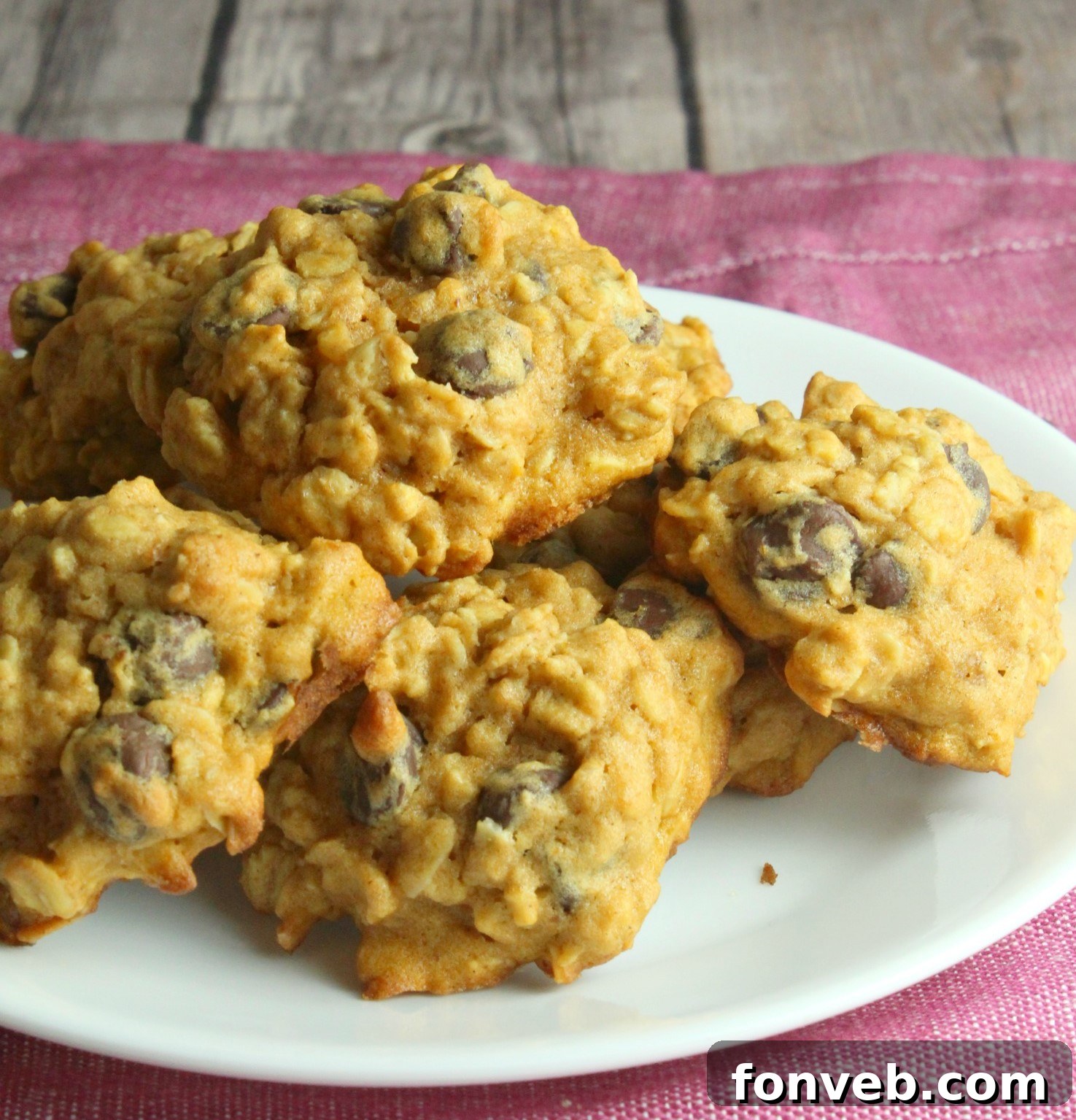 Freshly baked pumpkin oatmeal chocolate chip cookies on a cooling rack