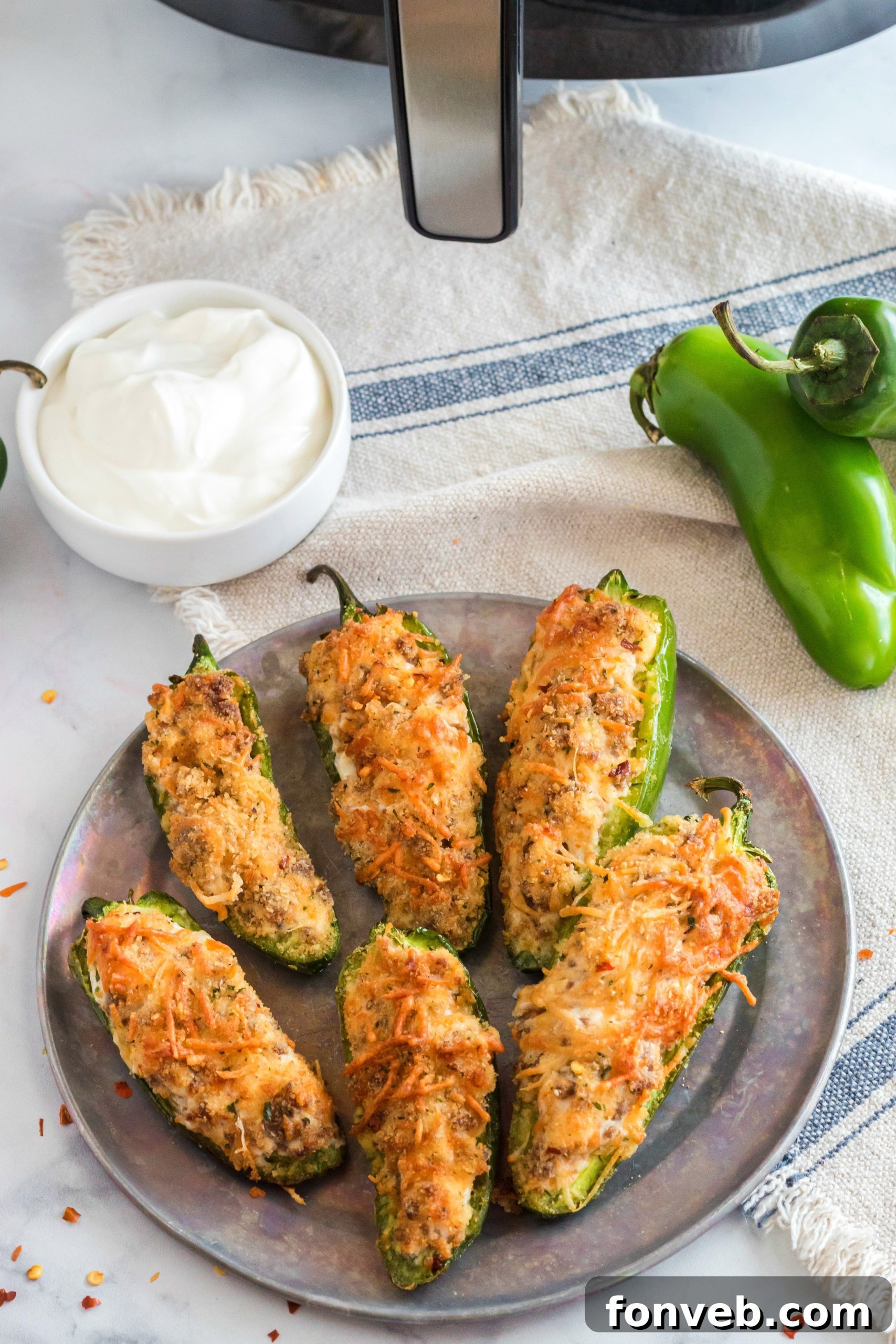 Air fryer basket filled with jalapeno poppers