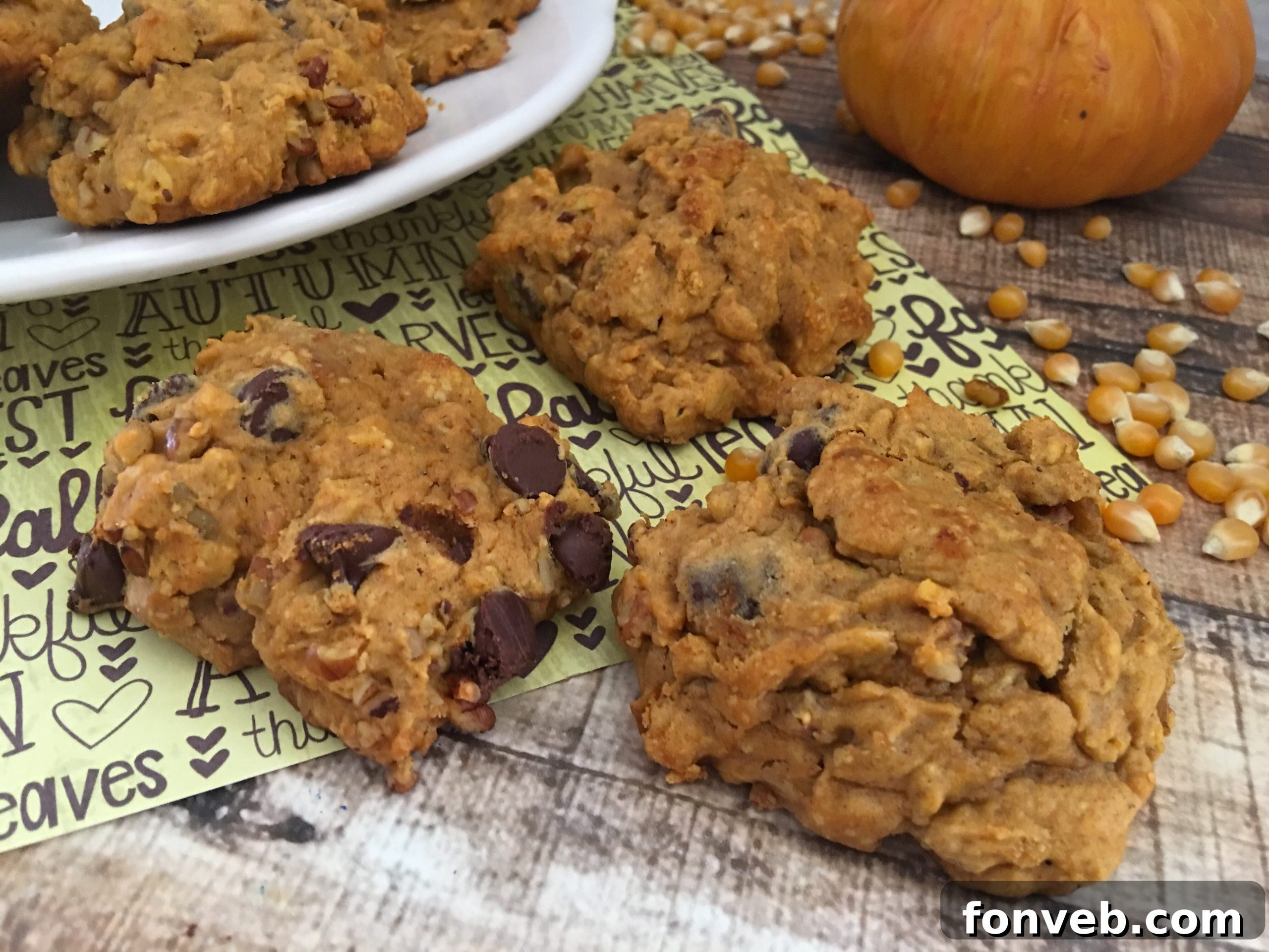 Spiced Pumpkin Pecan Chocolate Chip Cookies 4 A stack of golden brown pumpkin pecan chocolate chip cookies resting on a wire cooling rack, ready to be enjoyed