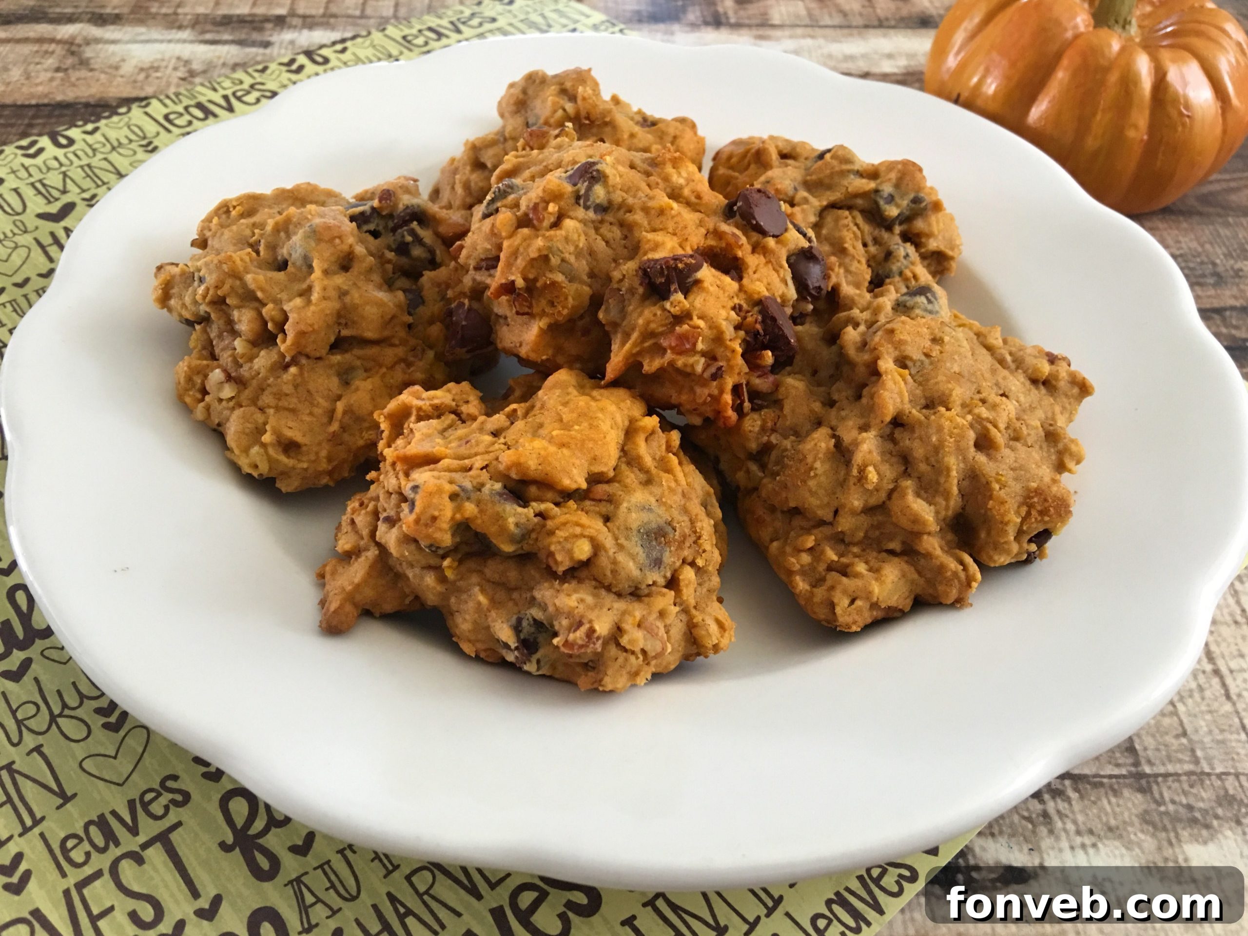 Spiced Pumpkin Pecan Chocolate Chip Cookies 5 A plate brimming with warm pumpkin pecan chocolate chip cookies, garnished with extra chocolate chips and pecans, inviting a delicious bite