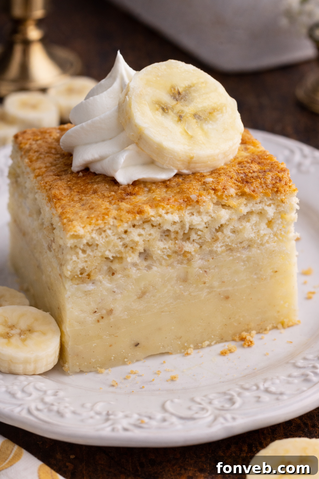 Banana Alchemy Cake 2 A beautifully presented slice of Banana Magic Cake on a white plate, showcasing its distinct three layers.