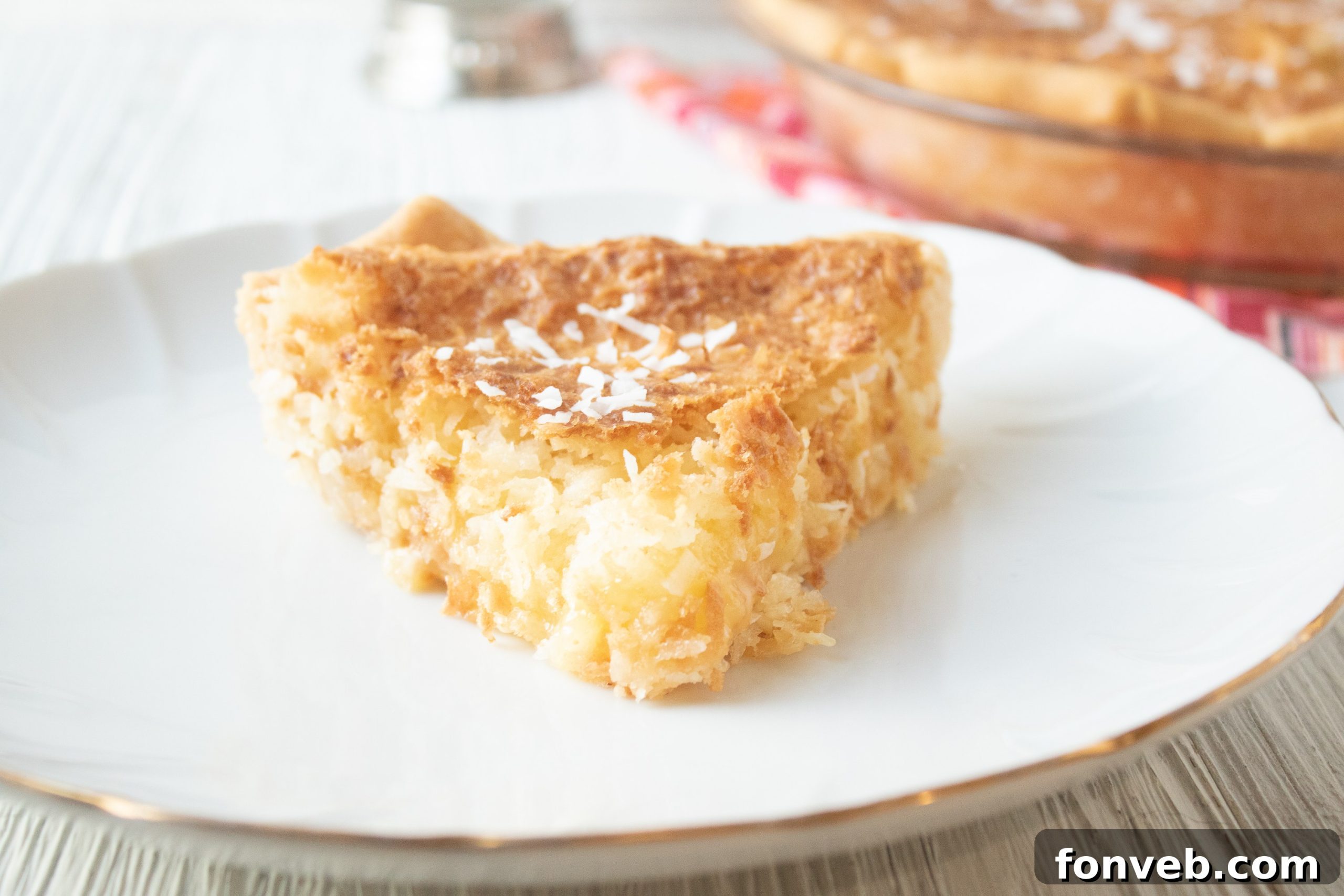 Nana's Classic Coconut Pie 7 A freshly baked coconut pie cooling on a wire rack, with some slices already taken.
