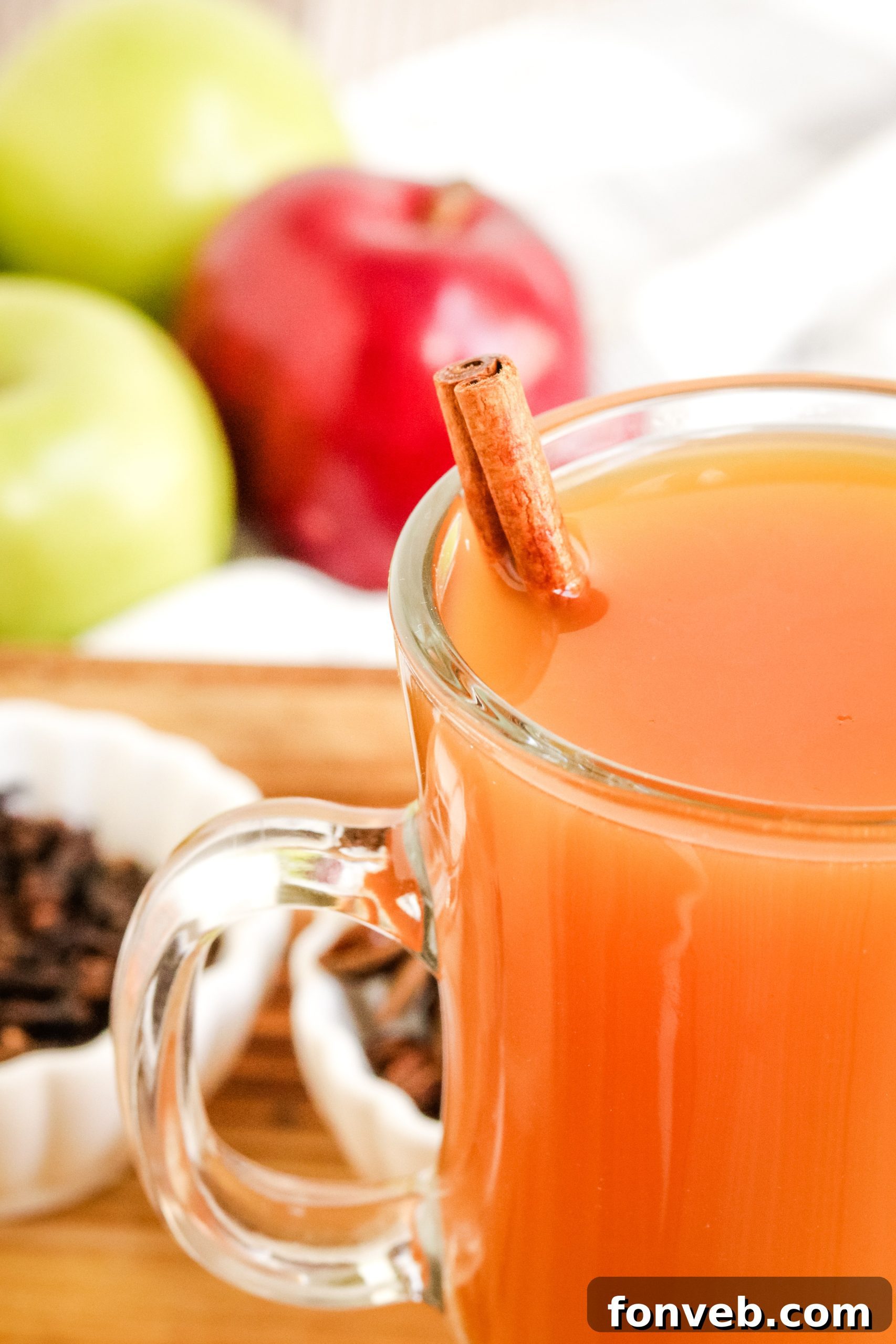 Cozy Slow Cooker Spiced Cider 7 Ingredients for mulled cider laid out on a table, including sliced apples, oranges, and various whole spices.