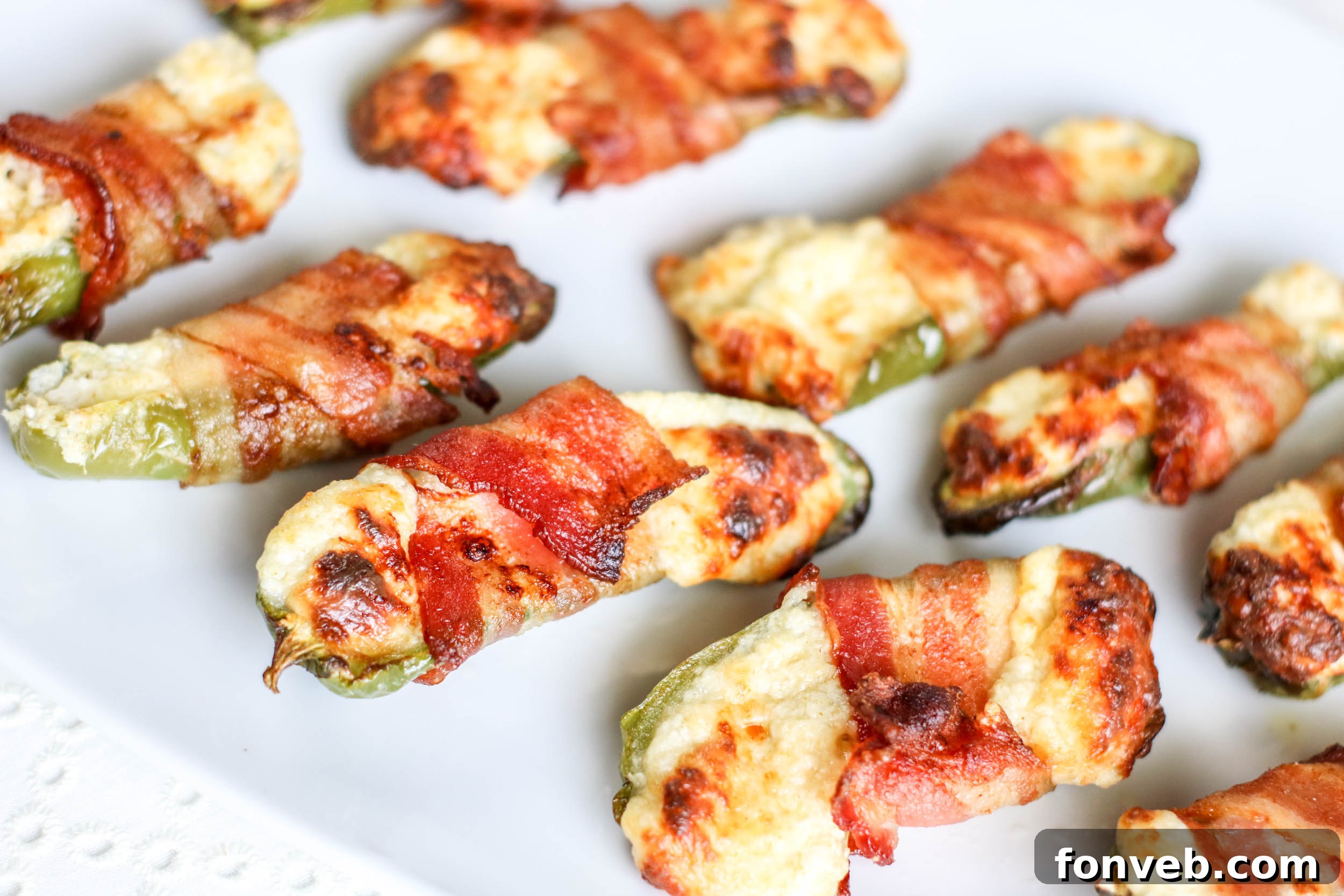 Crispy Keto Air Fryer Bacon Jalapeño Poppers 5 A close-up of a single Air Fryer Bacon Wrapped Jalapeno Popper, highlighting the crispy bacon and the golden-brown cheese peeking through.