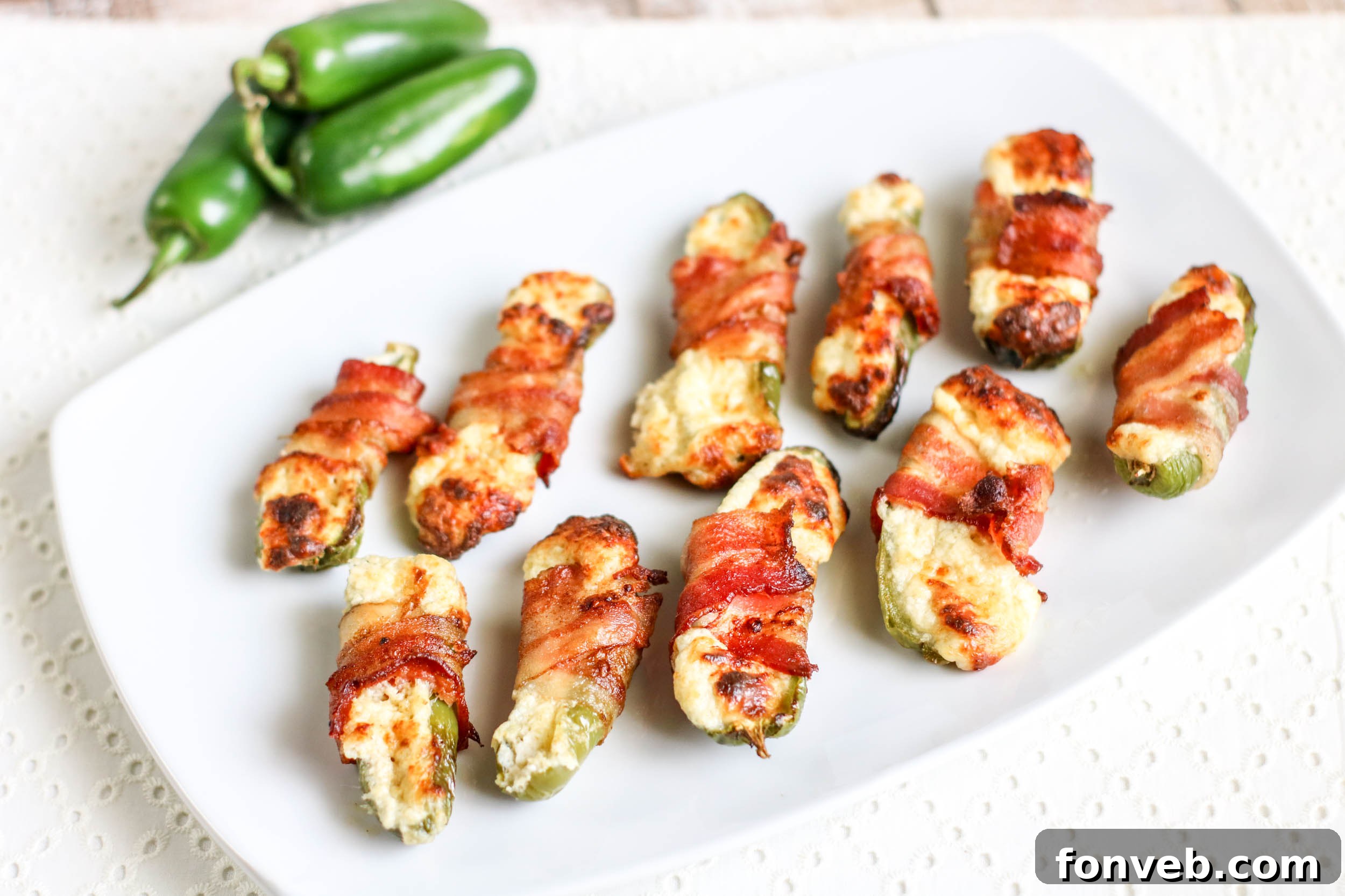 Crispy Keto Air Fryer Bacon Jalapeño Poppers 7 A serving of Air Fryer Bacon Wrapped Jalapeno Poppers with a side of creamy dipping sauce, perhaps ranch or sour cream.