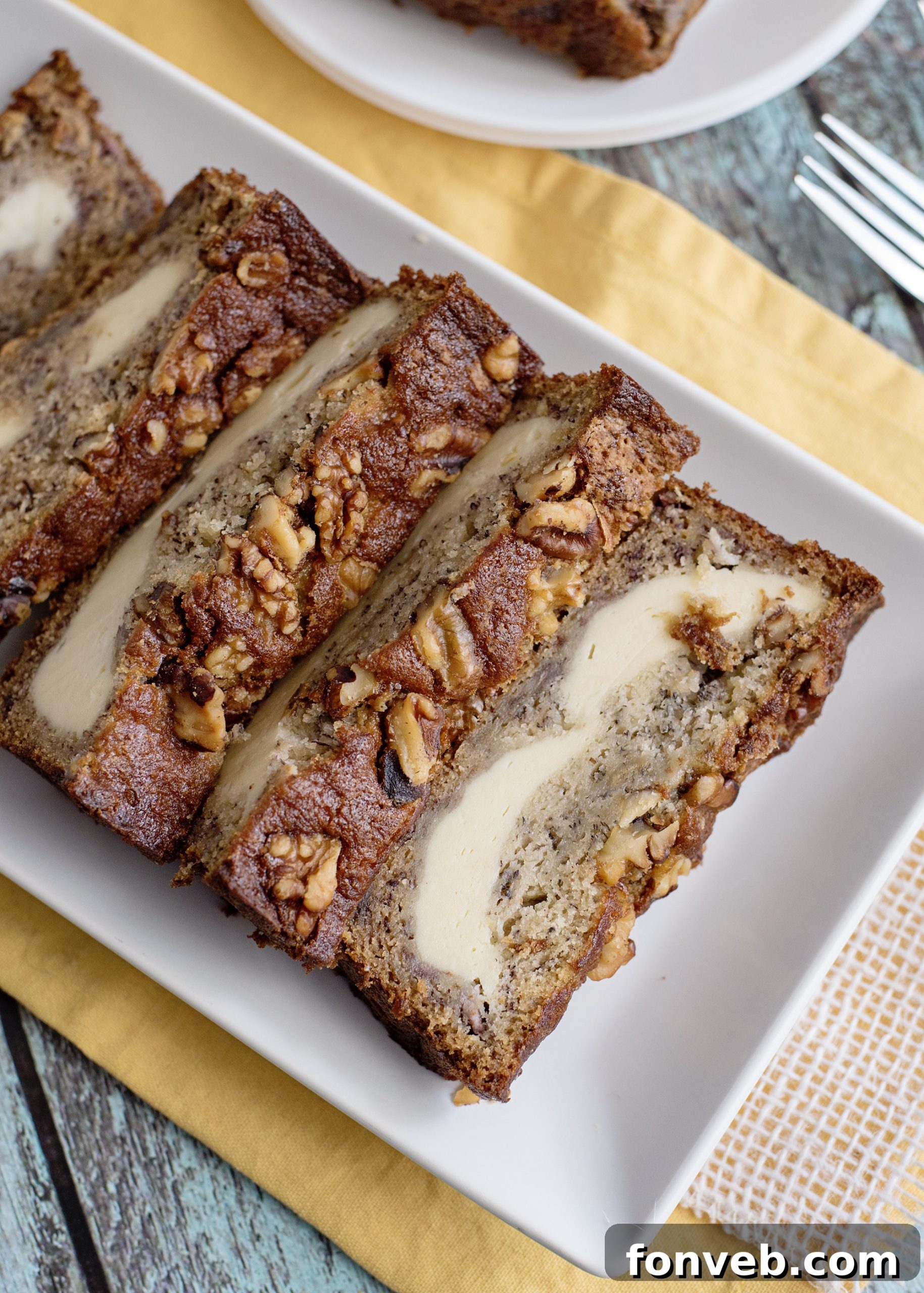 Cross-section of banana bread revealing cream cheese layer.