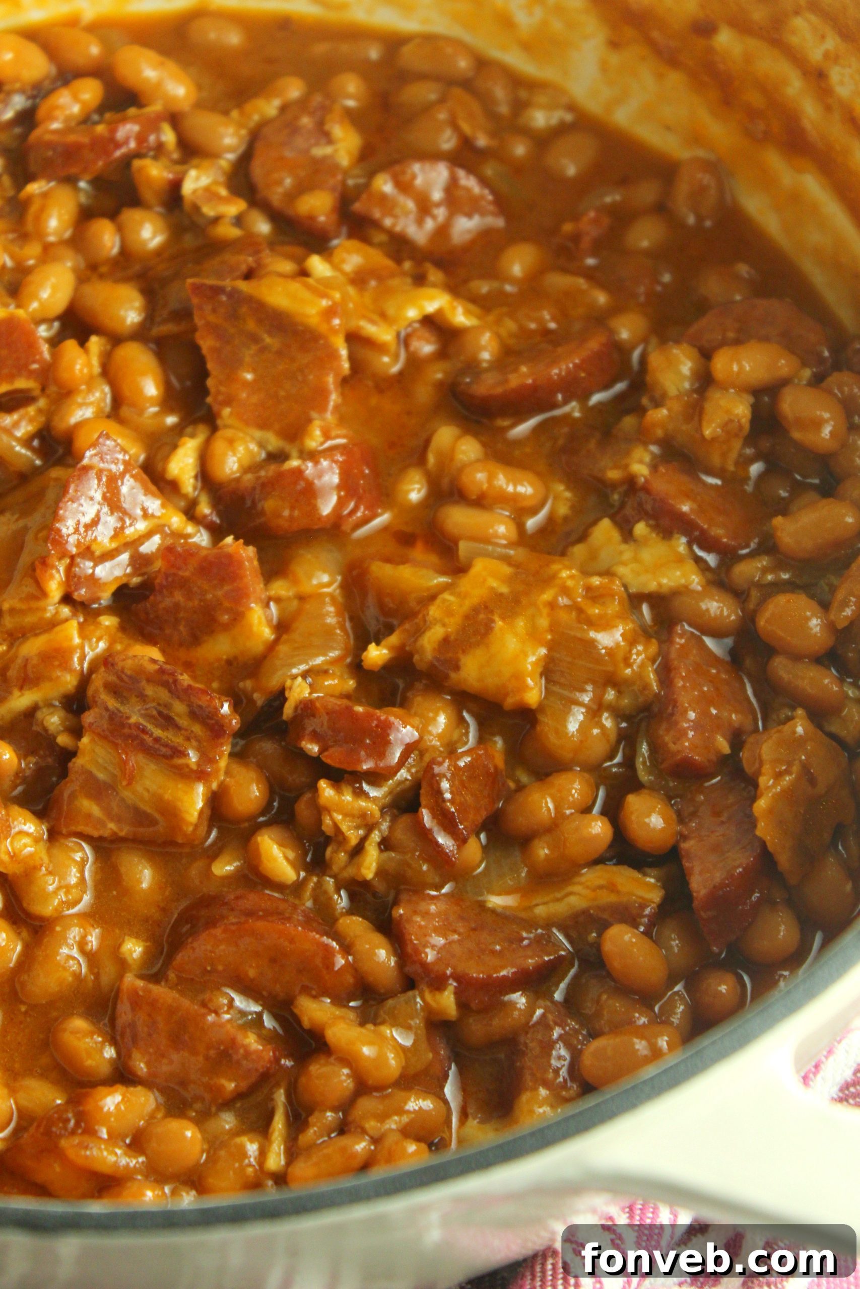 Signature Smoked Sausage Baked Beans 11 A vibrant close-up of Ultimate Baked Beans with Smoked Sausage, rich with sauce and meat